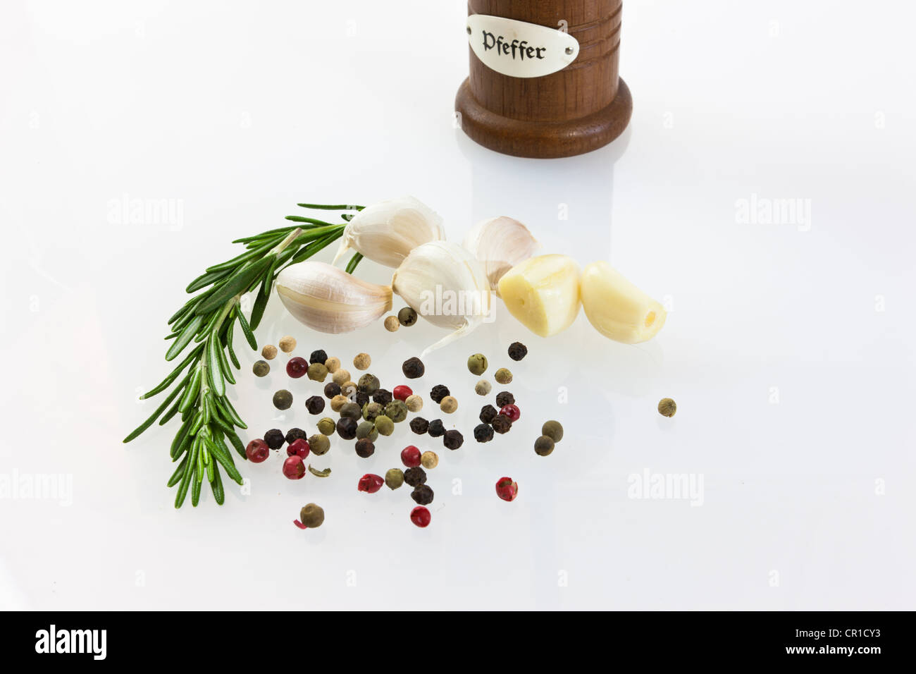 Garlic (Allium sativum) with pepper mill, fresh rosemary, black and red