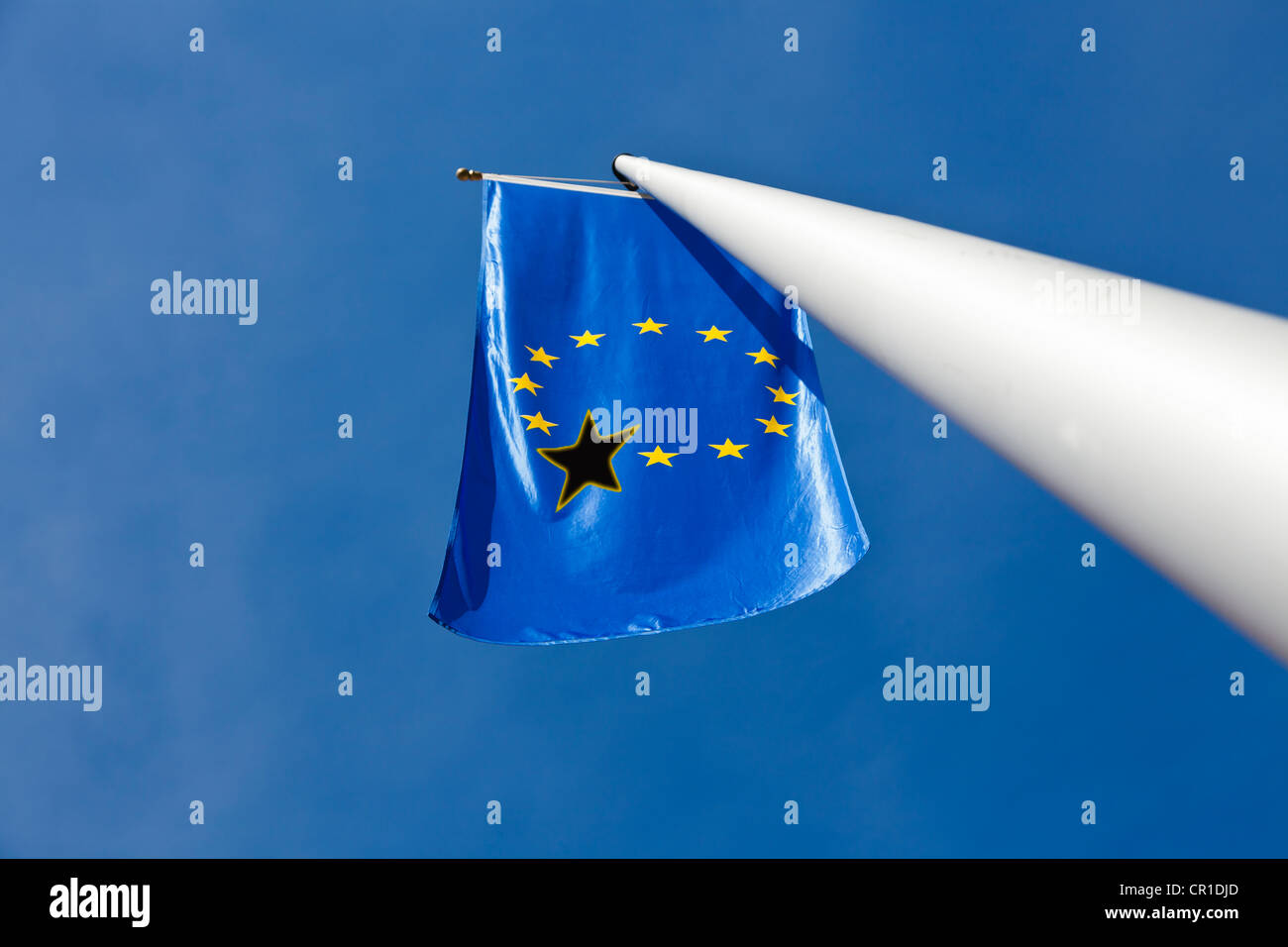 European flag with EU stars and one black star, on a flagpole, symbolic image Stock Photo