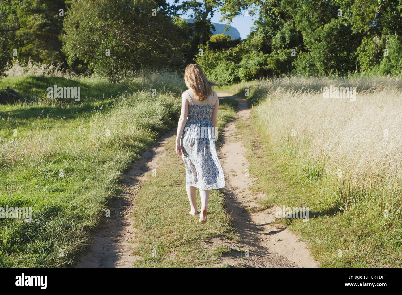 Teenage girl walking on dirt path Stock Photo