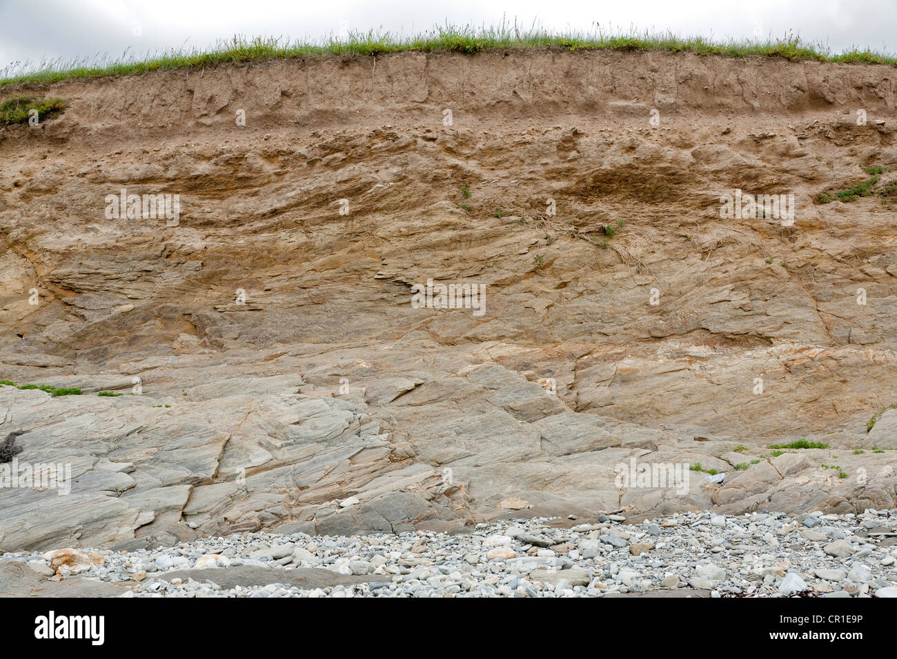 coastal proterozoic rock deposits forming a low cliff on the Brittany coast at Plozevet Stock Photo