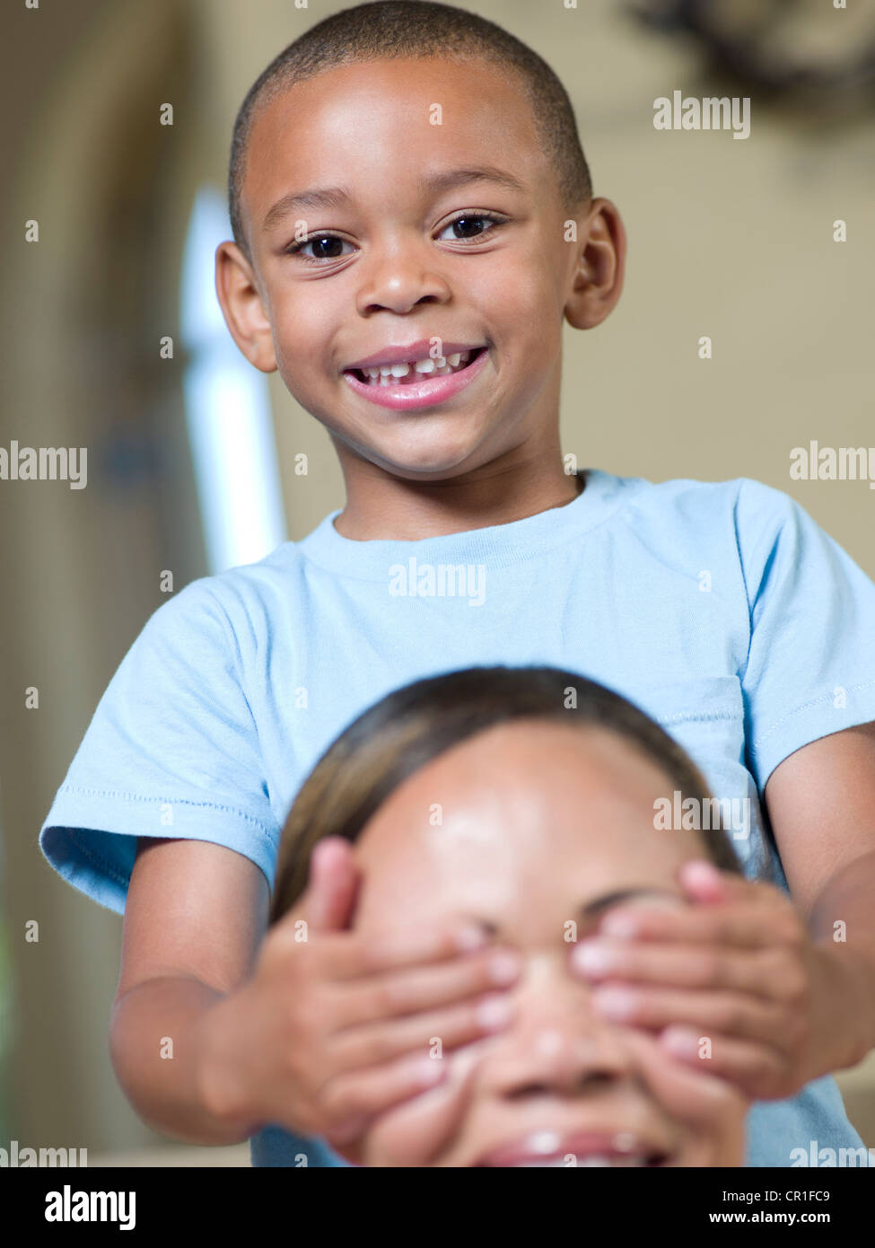 Smiling boy covering mothers eyes Stock Photo