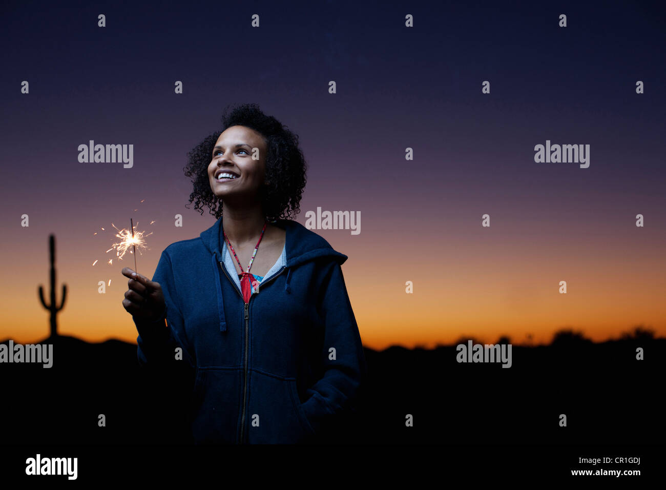Woman playing with sparkler in desert Stock Photo