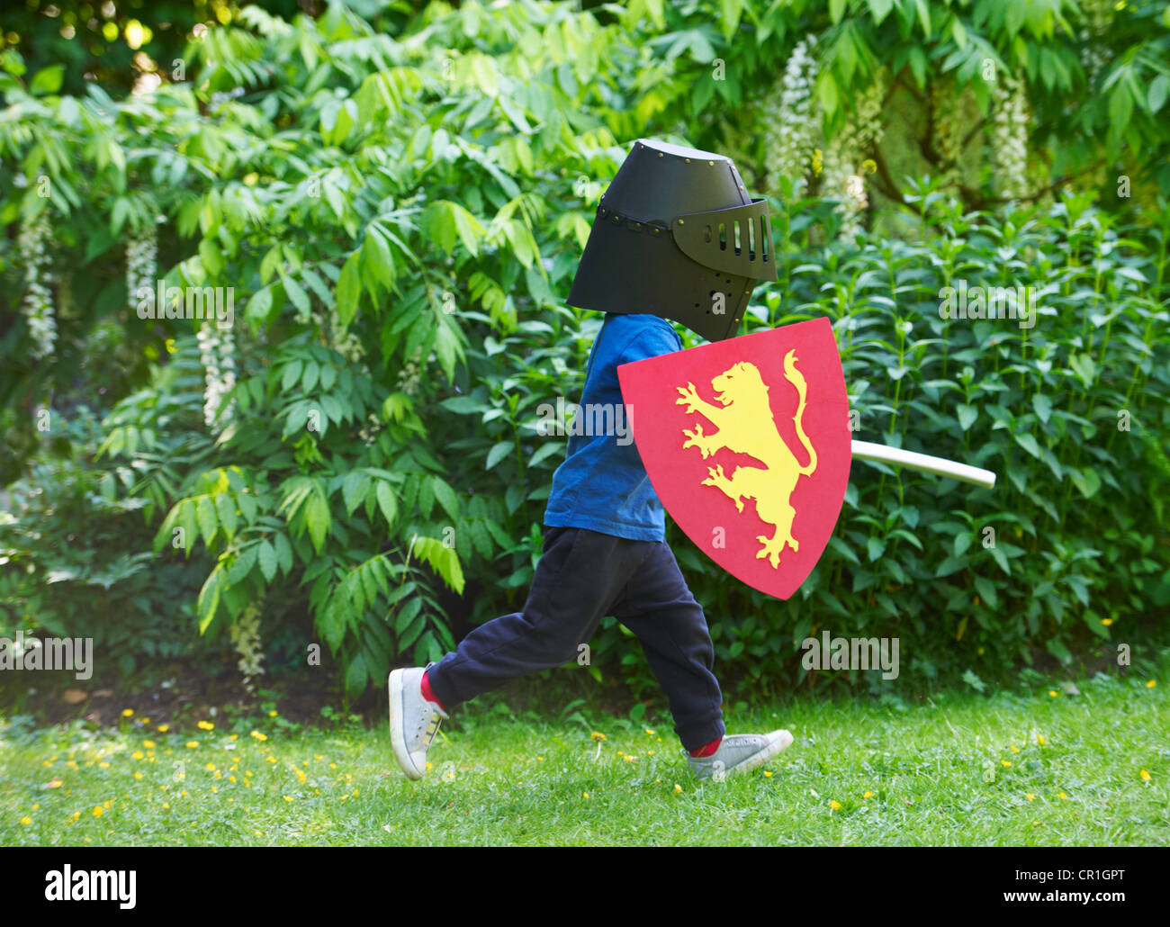 Boy playing with sword in backyard Stock Photo