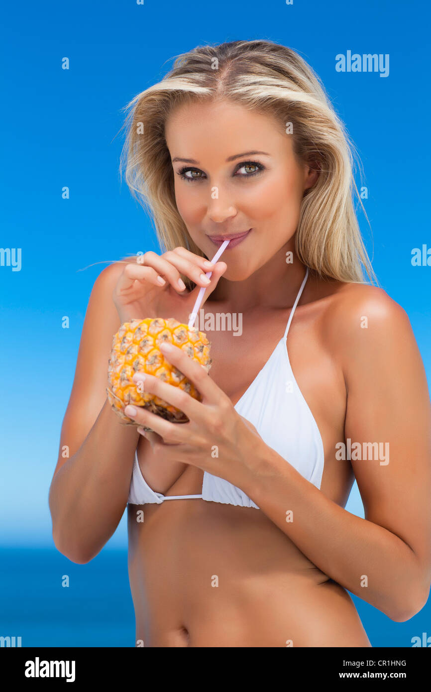 Woman drinking from pineapple outdoors Stock Photo