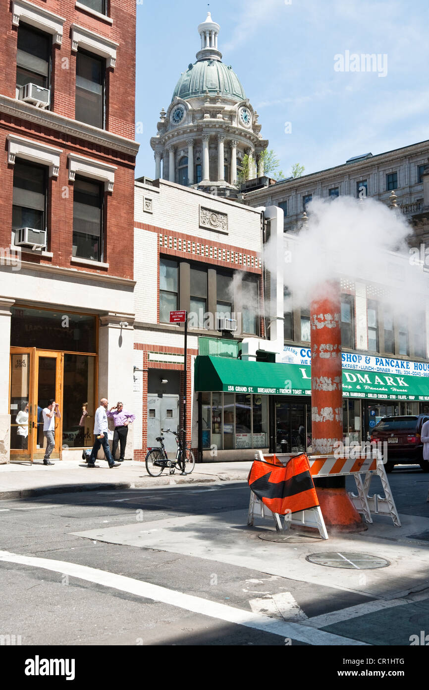 New York street scene Grand street with ubiquitous steam pipe vent & view of copper dome landmarked former Police Headquarters Stock Photo