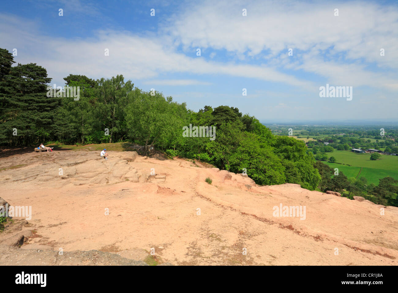 Two walkers looking across the Cheshire Plain from Stormy Point on Alderley Edge, Cheshire