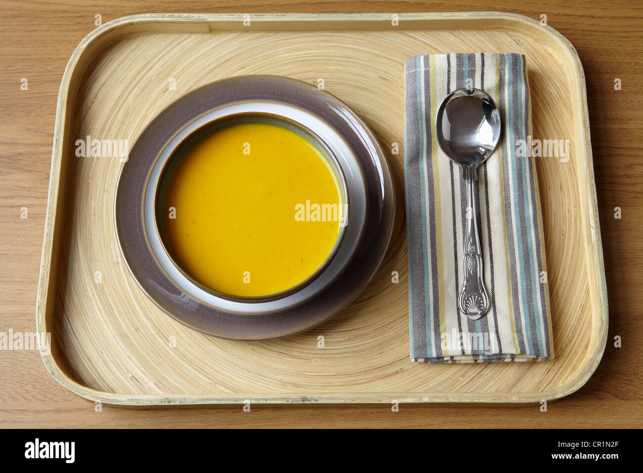 Tray with bowl of soup and spoon Stock Photo