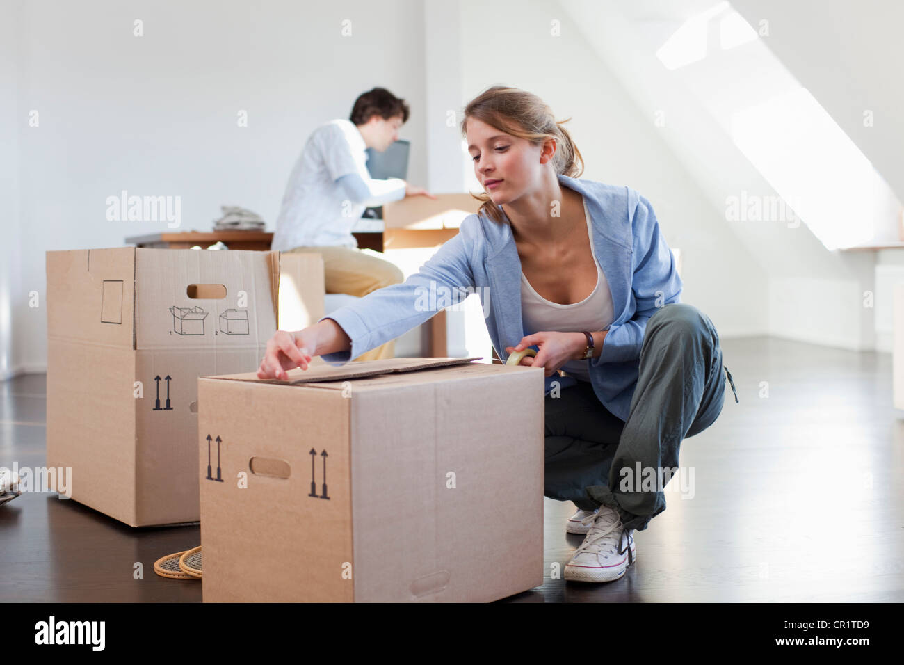 Woman taping up cardboard box Stock Photo Alamy