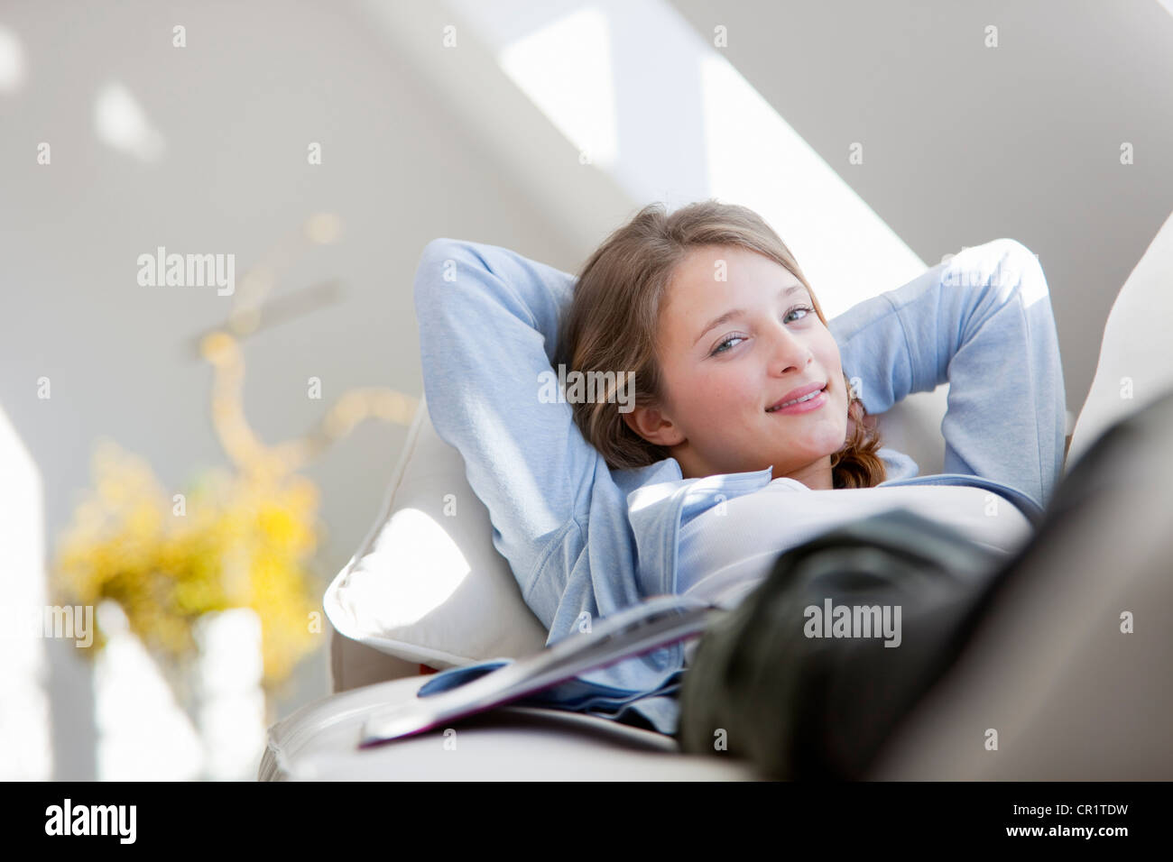 Smiling woman relaxing on sofa Stock Photo - Alamy