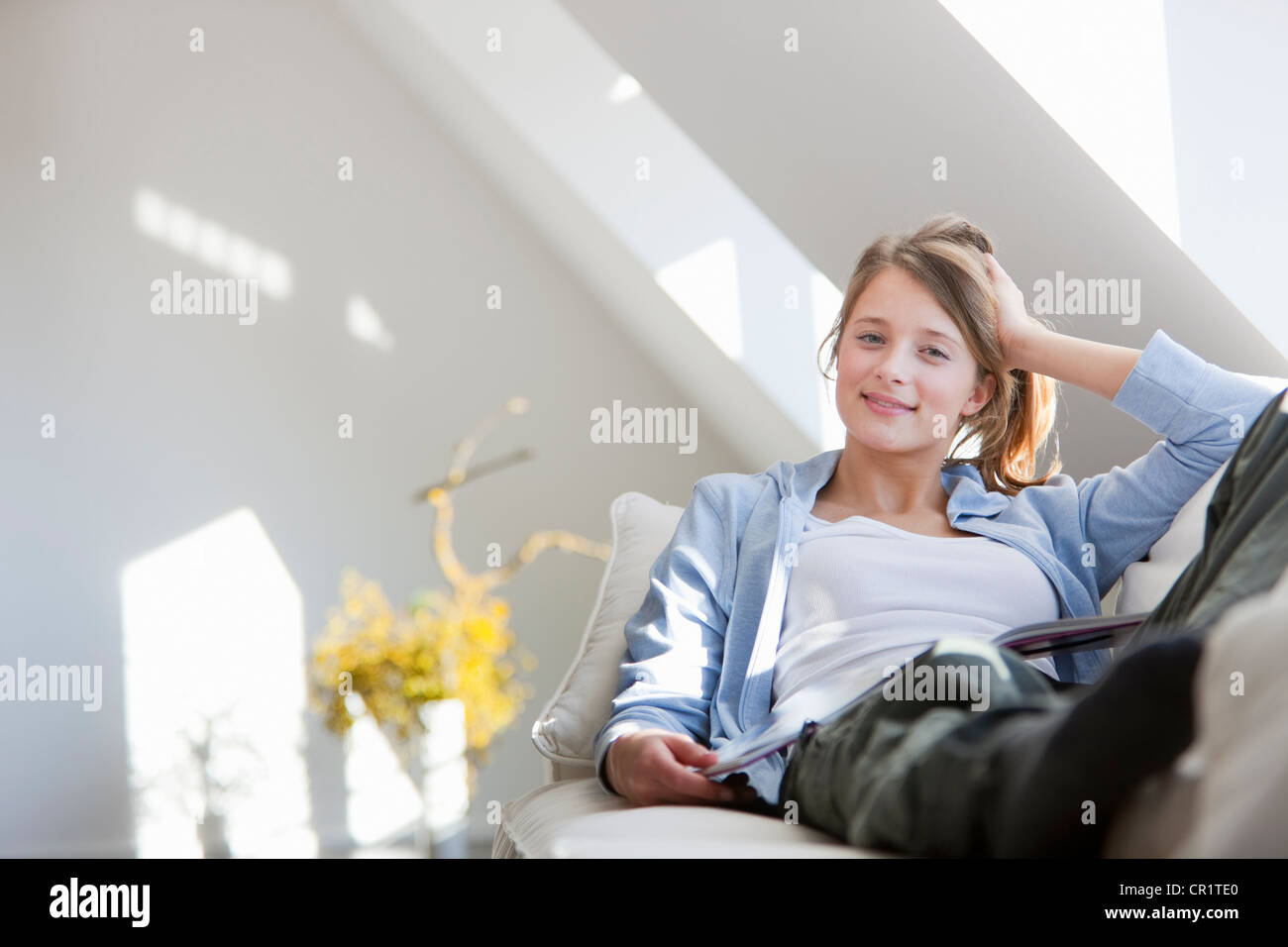 Smiling woman relaxing on sofa Stock Photo - Alamy