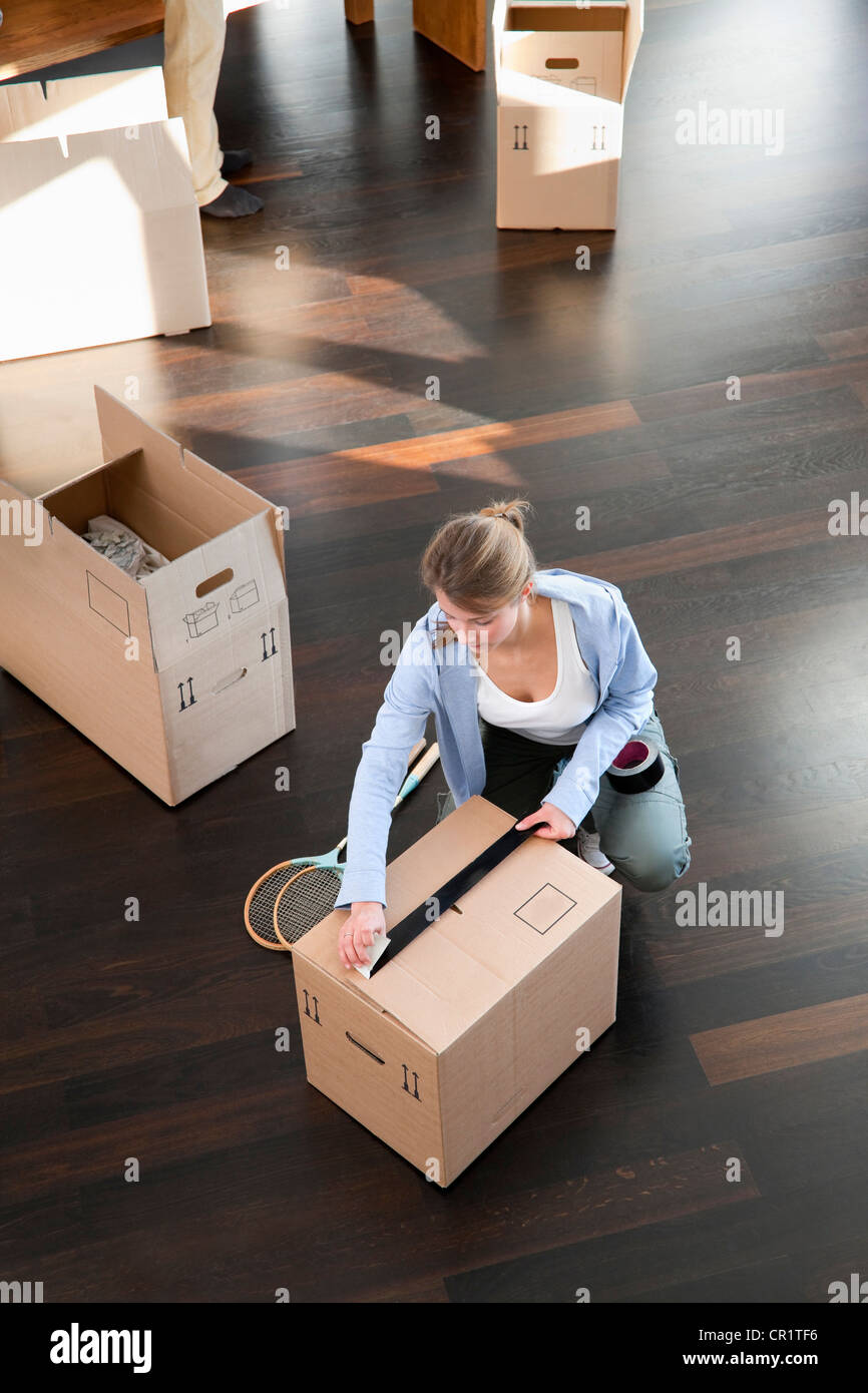 Woman taping up cardboard box Stock Photo Alamy