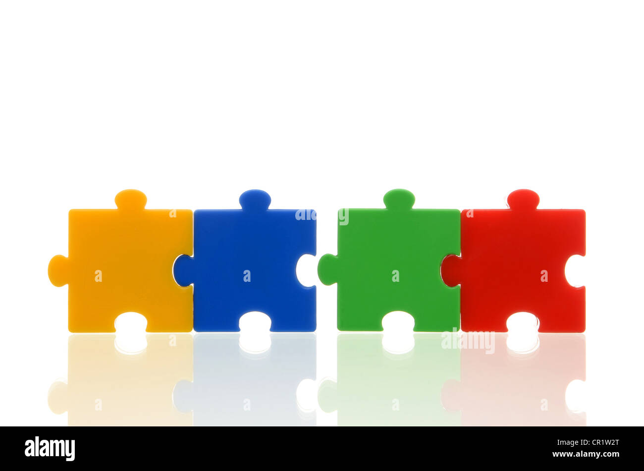 Different coloured puzzle pieces, two pairs of two connected puzzle pieces, symbolic image for team, series Stock Photo
