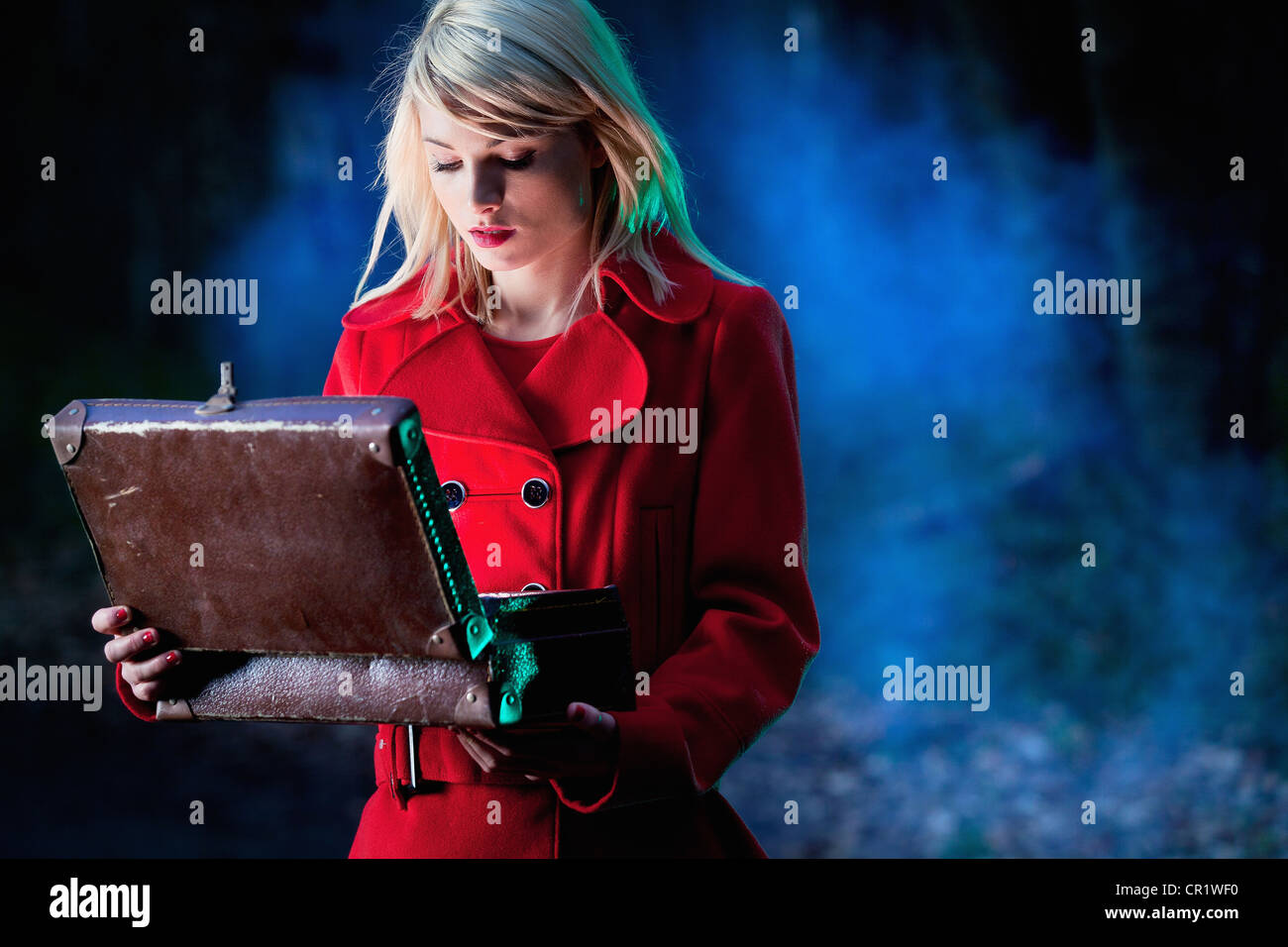 Woman examining contents of suitcase Stock Photo