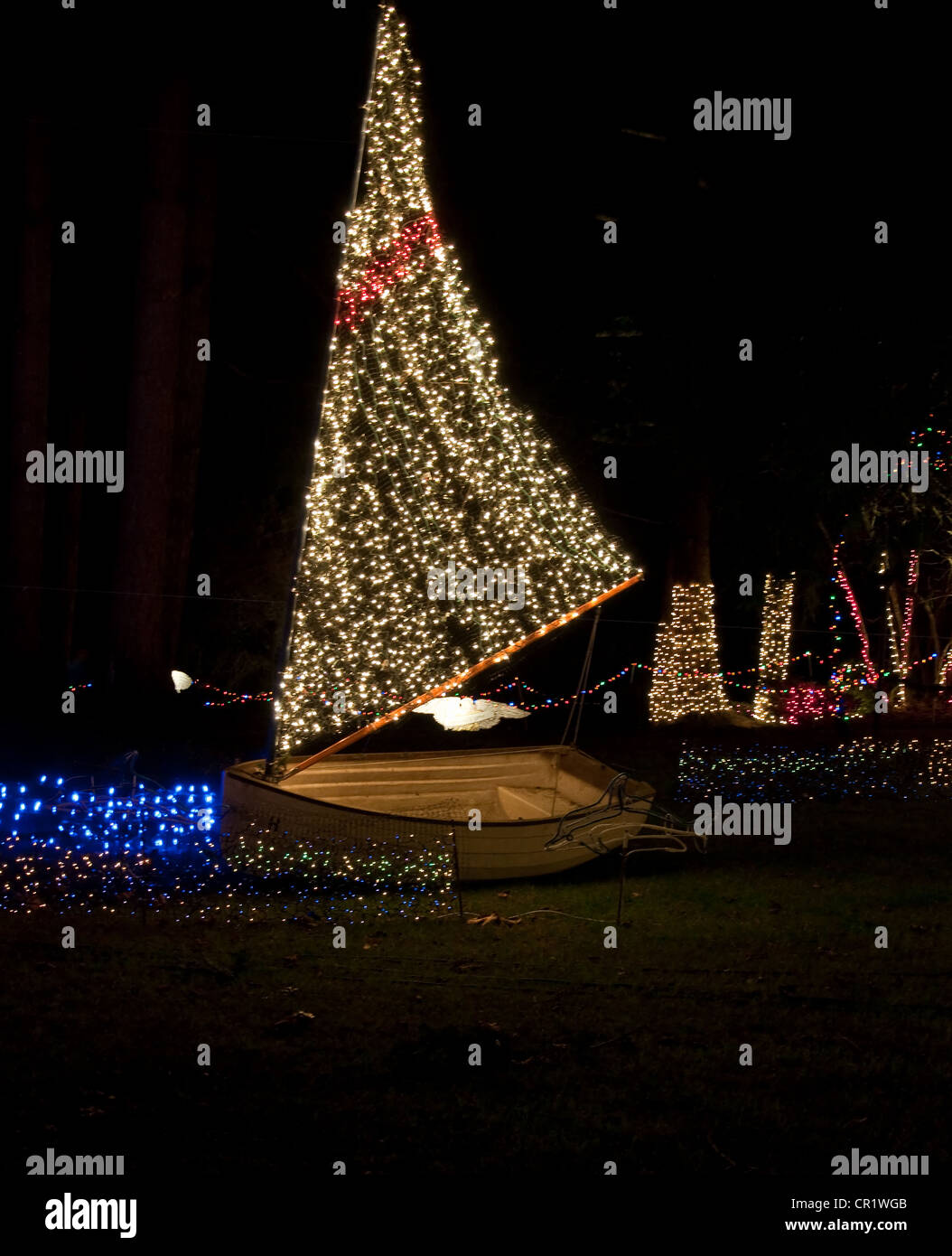 This vertical holiday image is a sailboat with Christmas lights at night for a holiday display