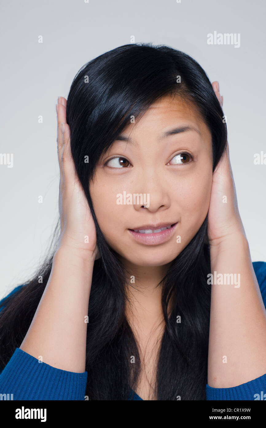 Studio portrait of young woman covering ears Stock Photo Alamy