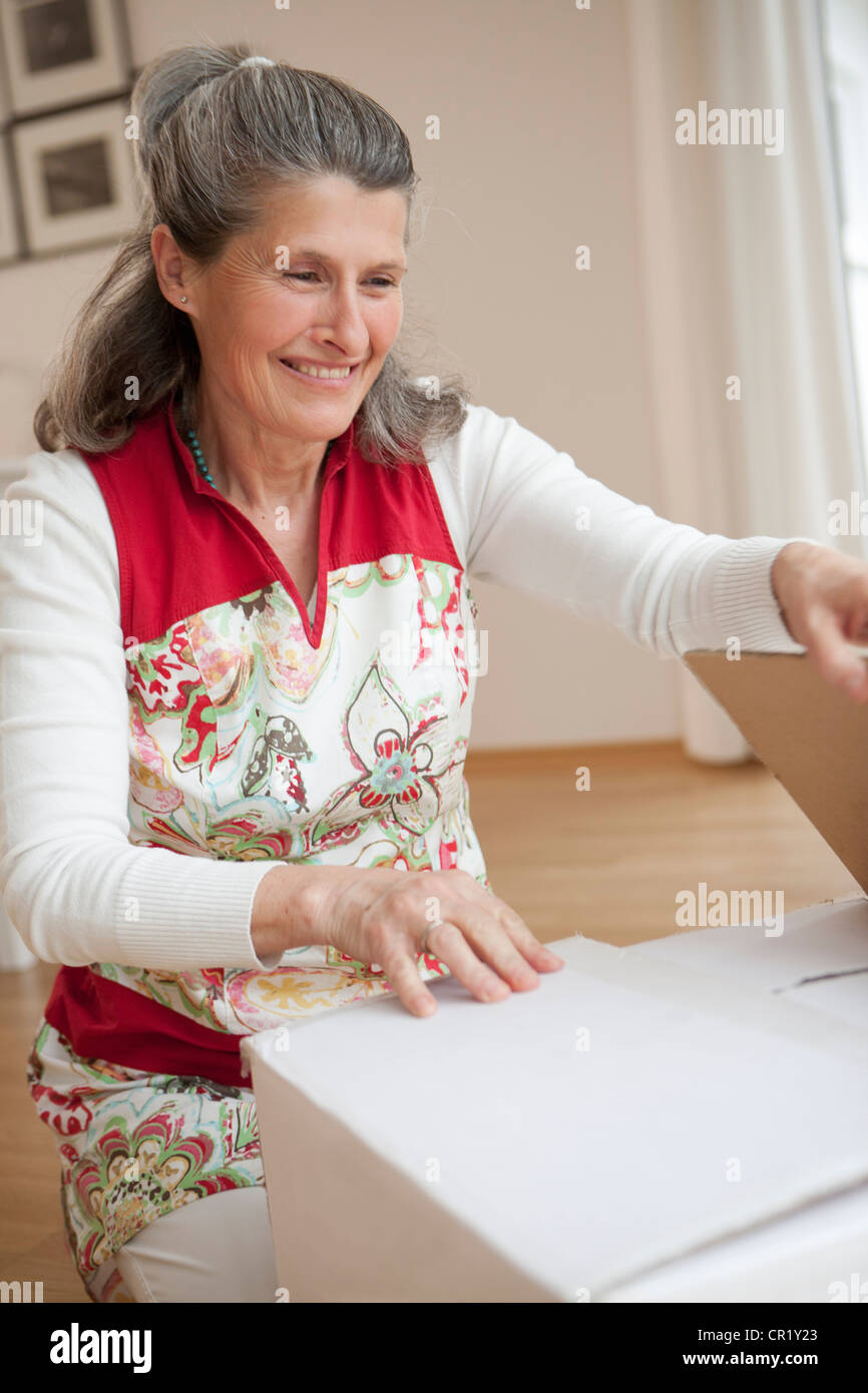 Older woman unpacking box Stock Photo