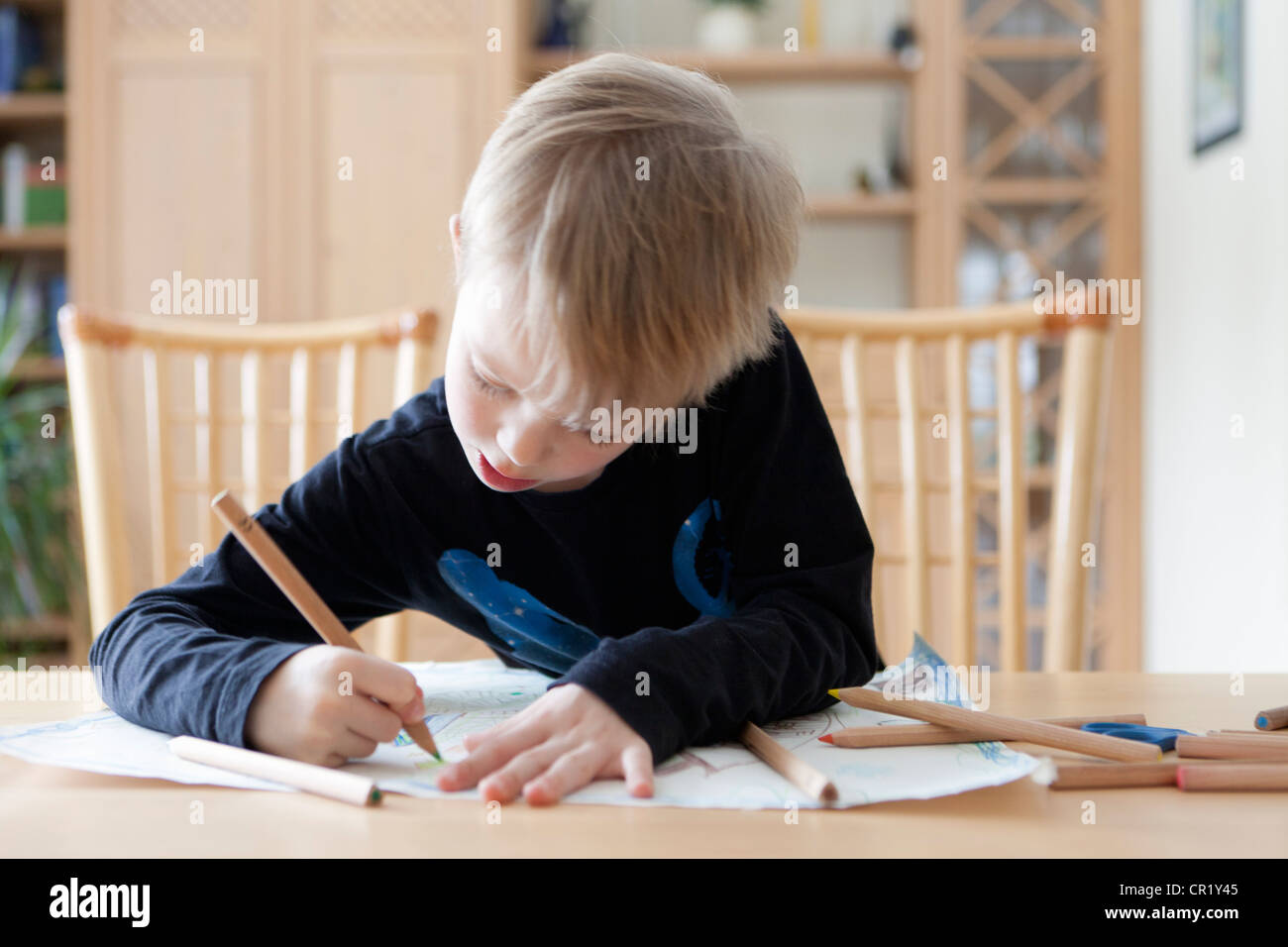 Boy drawing with colored pencils Stock Photo