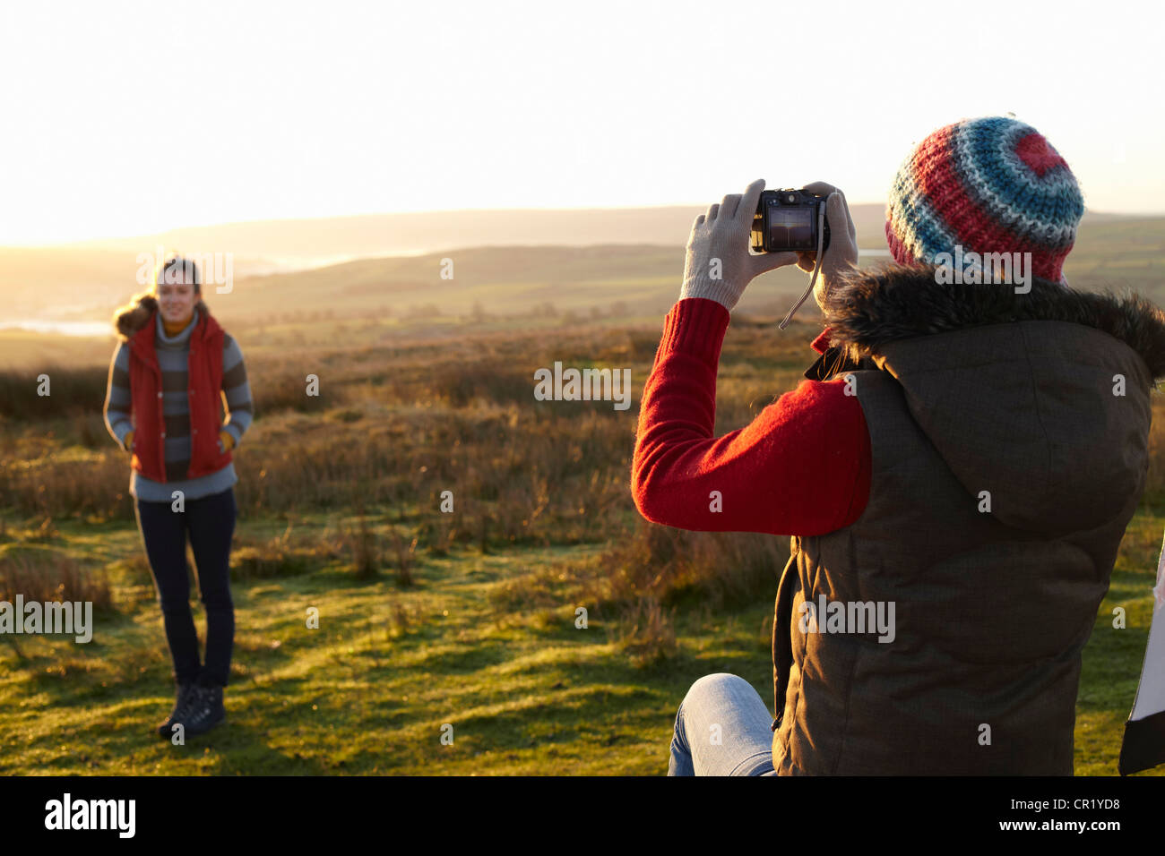 Woman taking picture of friend outdoors Stock Photo