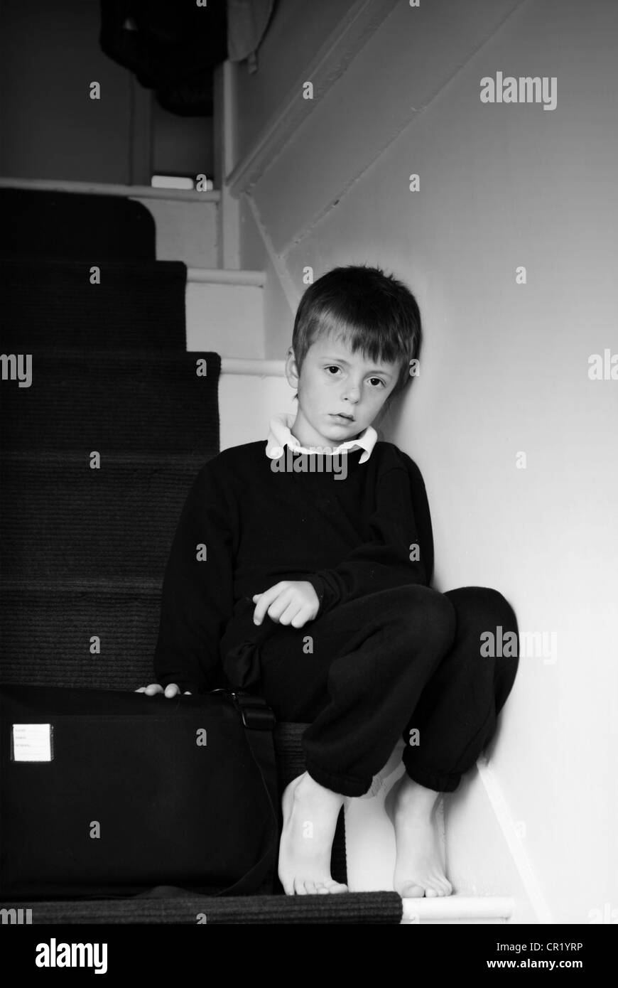 Lonely child sitting on the stairs. Stock Photo