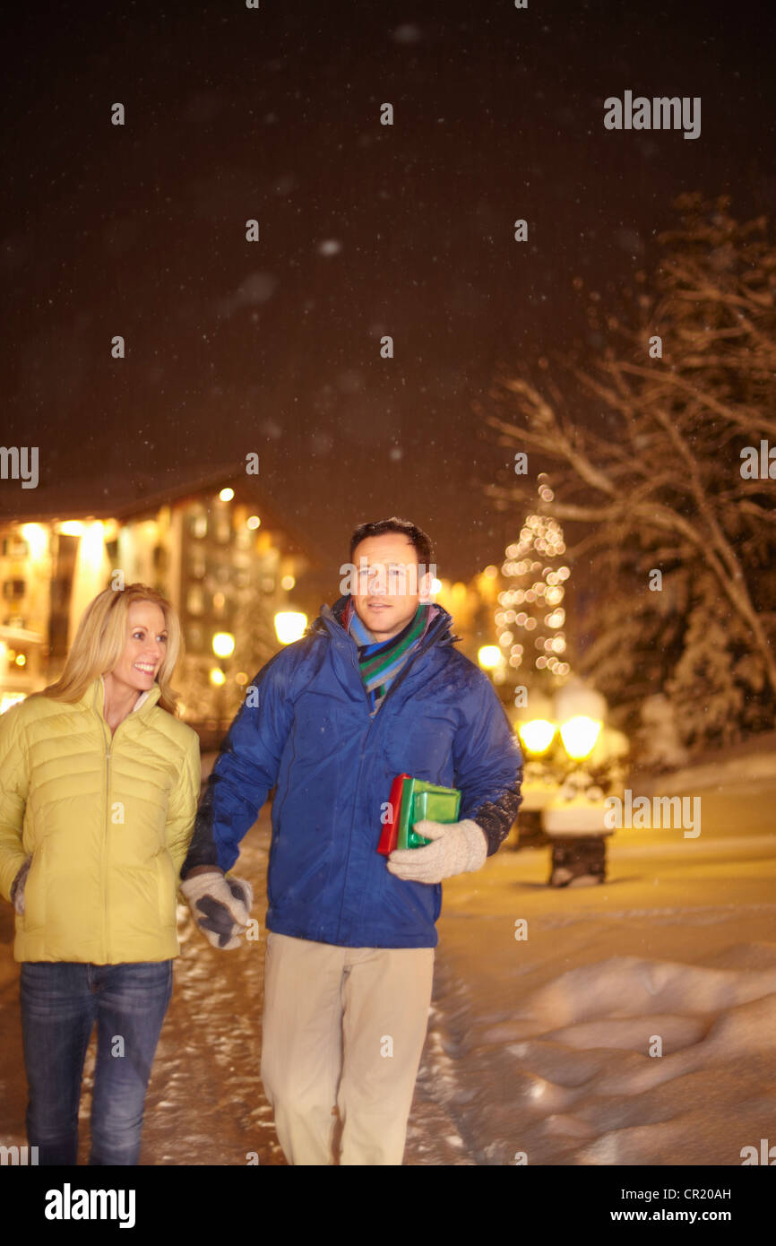 Couple walking together in snow Stock Photo