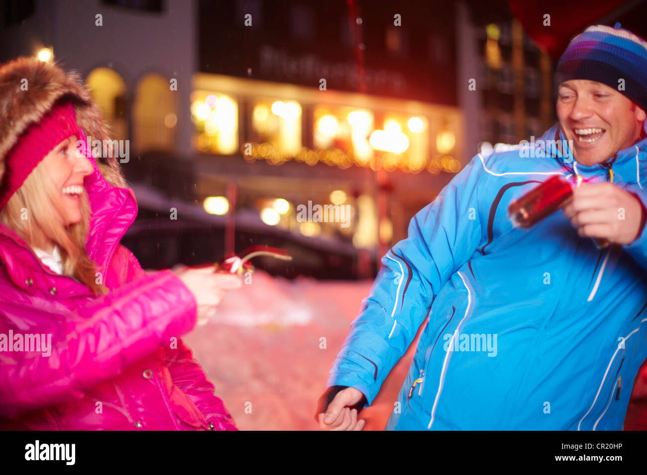 Couple pulling Christmas cracker in snow Stock Photo