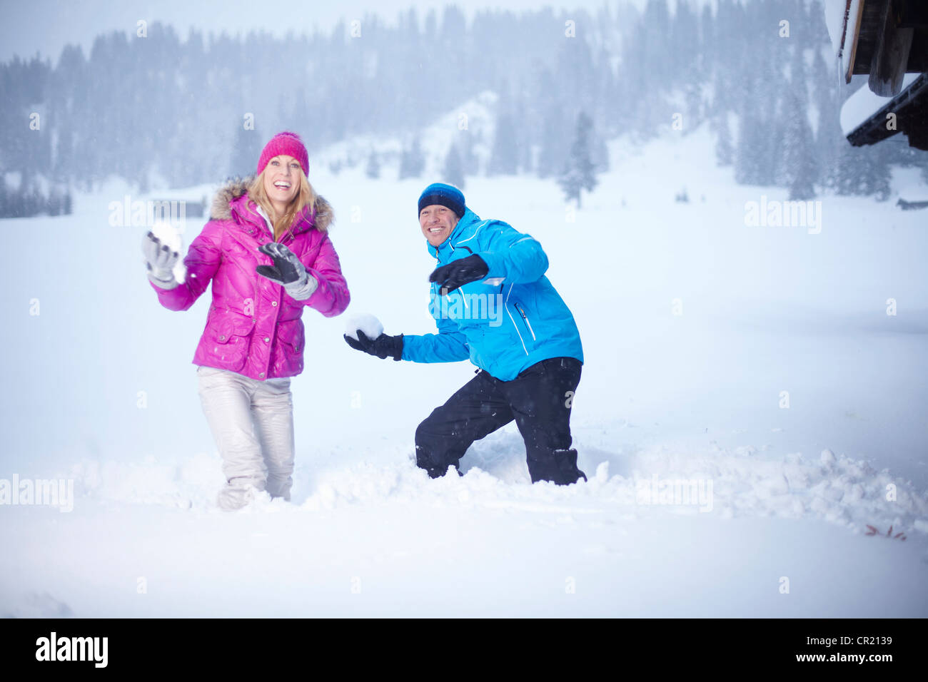 Couple having snowball fight outdoors Stock Photo