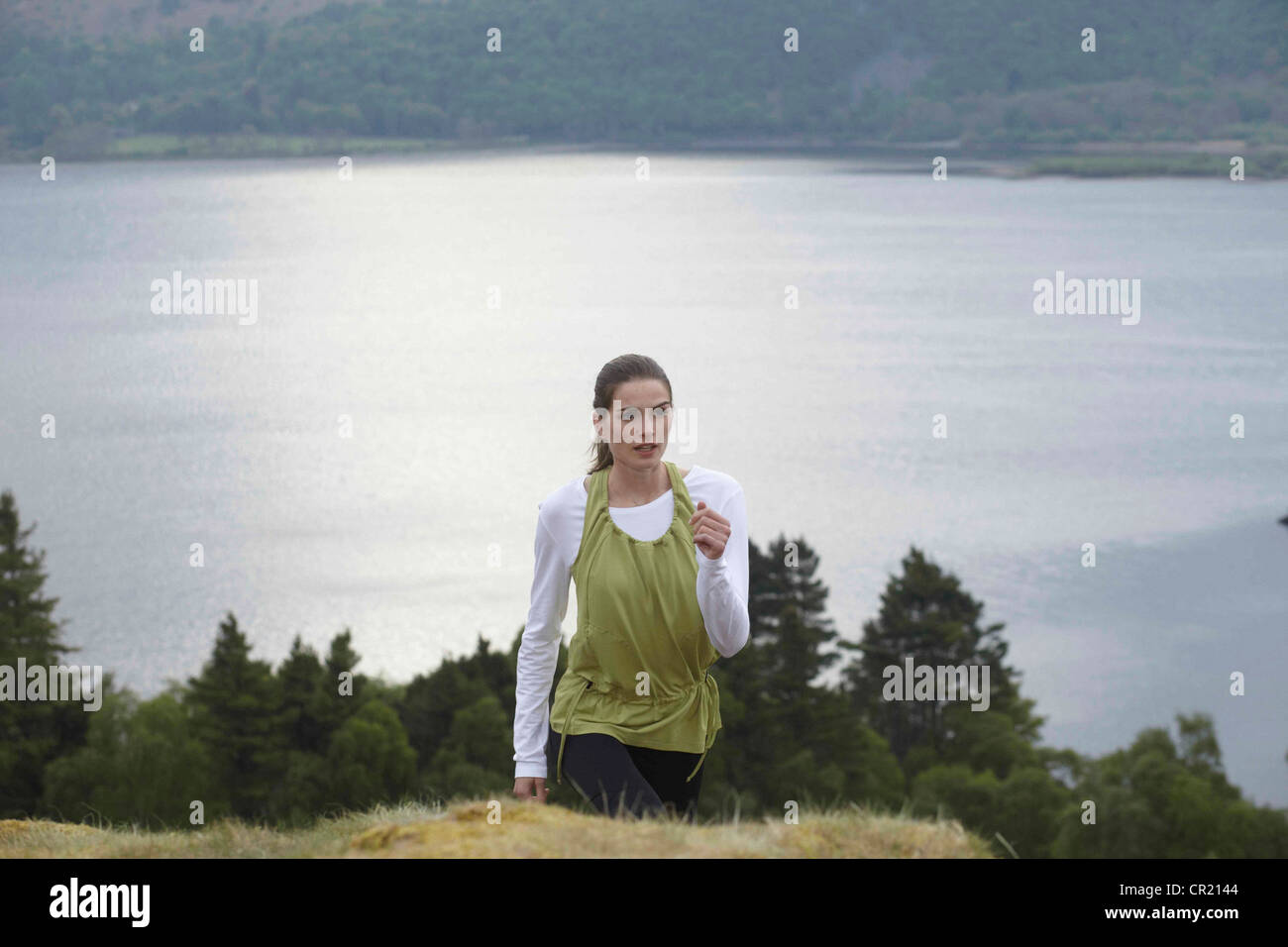 Woman climbing rural hill Stock Photo Alamy