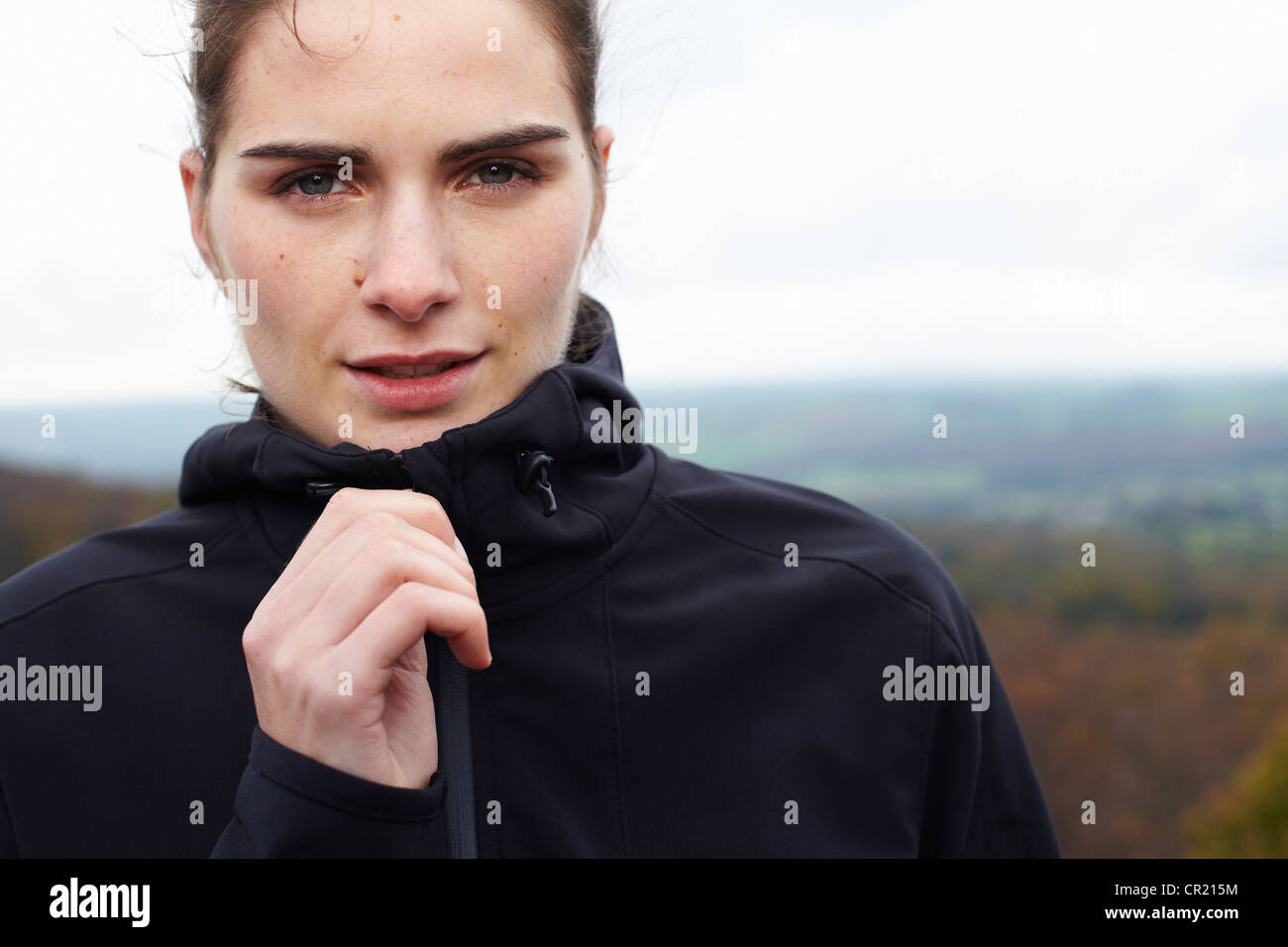 Close up of woman zipping up coat Stock Photo