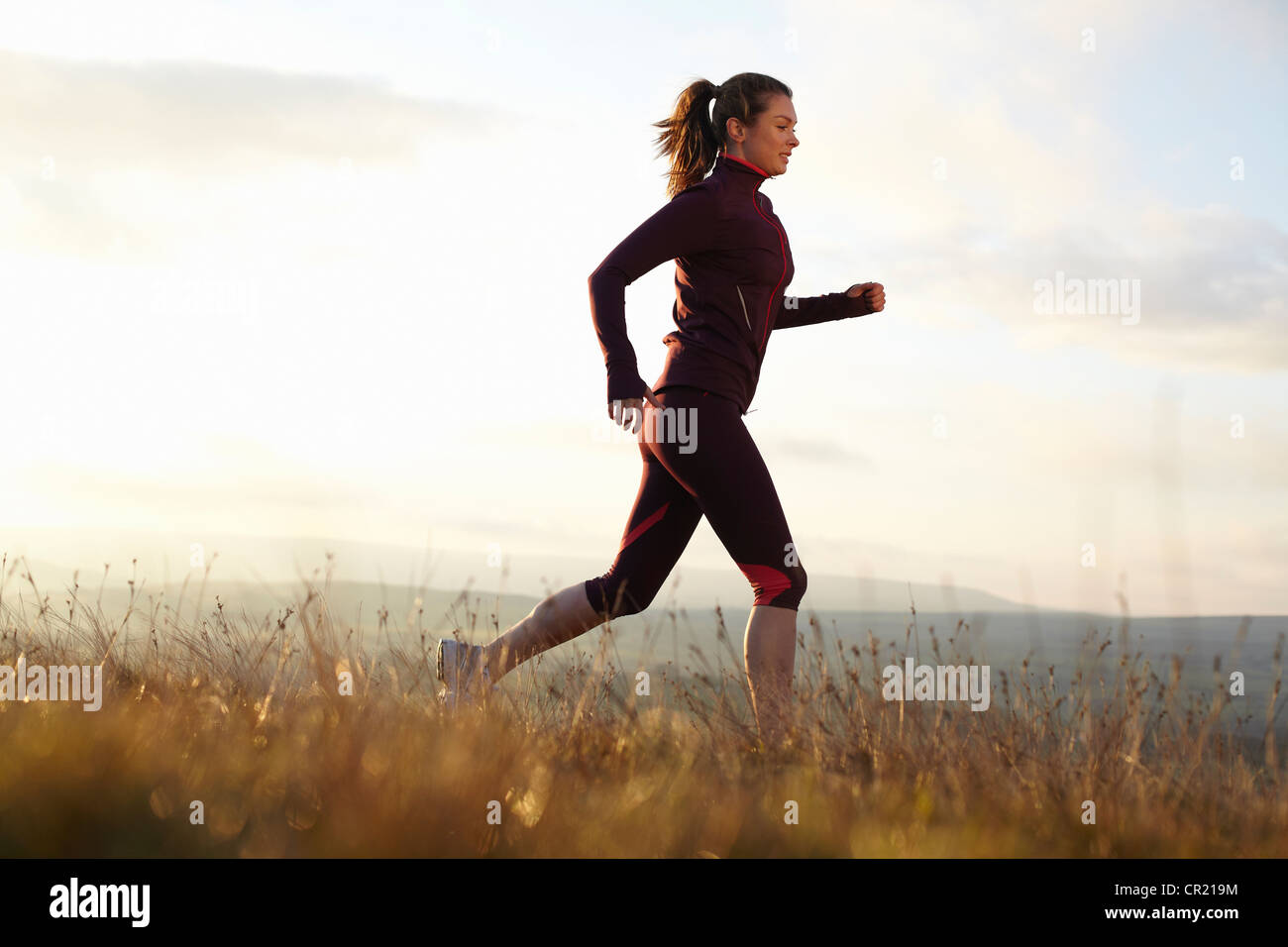 Woman running in rural field Stock Photo