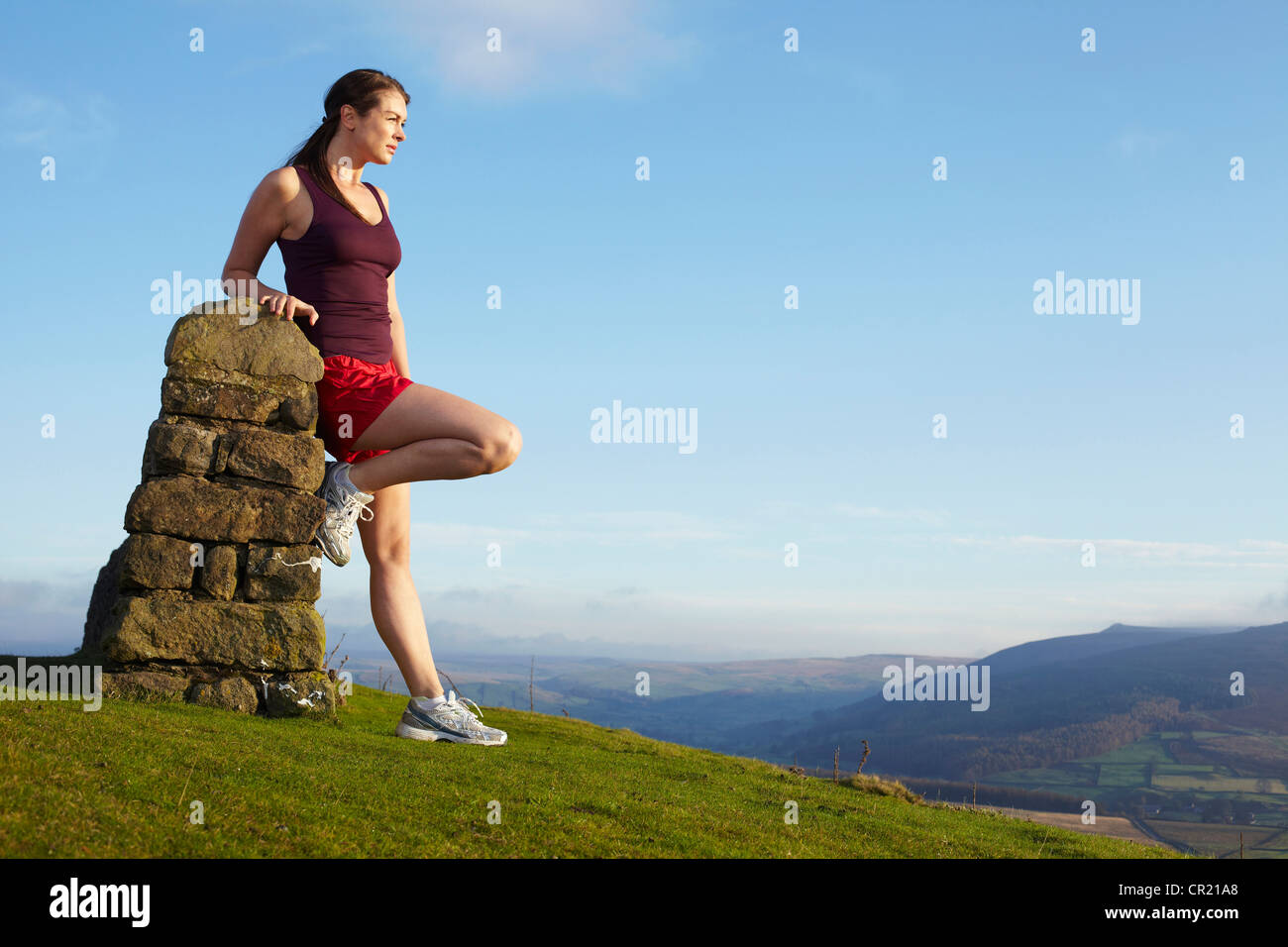 Runner leaning against rock wall Stock Photo
