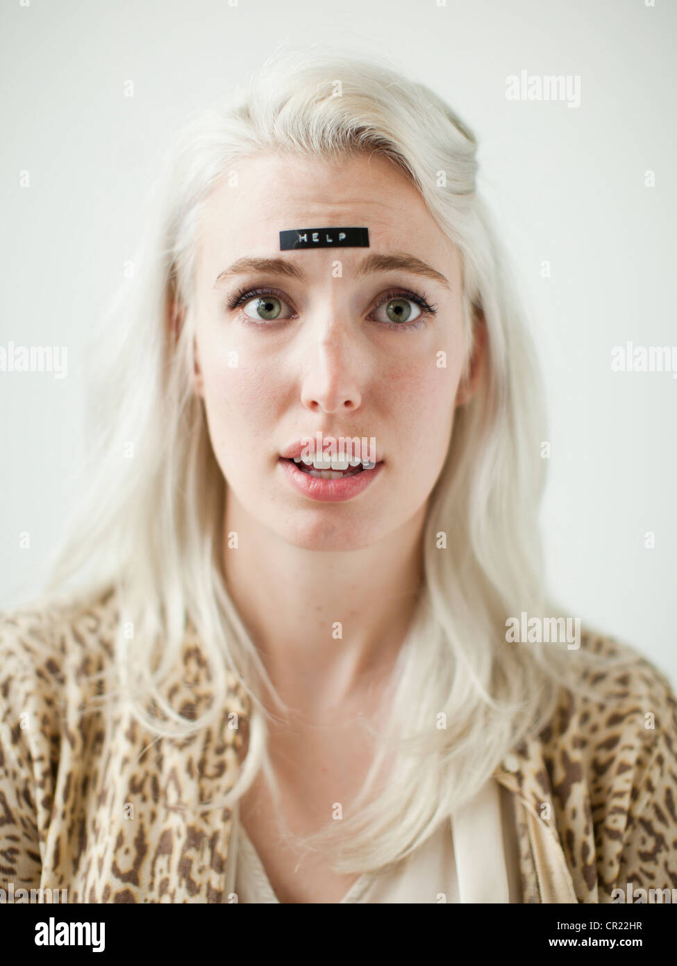 Portrait of young woman with word help on forehead Stock Photo