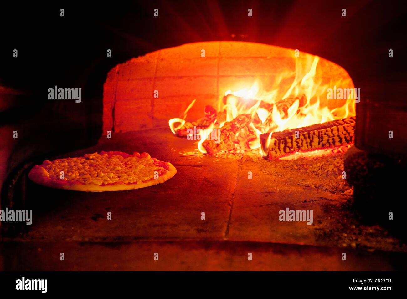 Pizza baking in wood burning oven Stock Photo Alamy