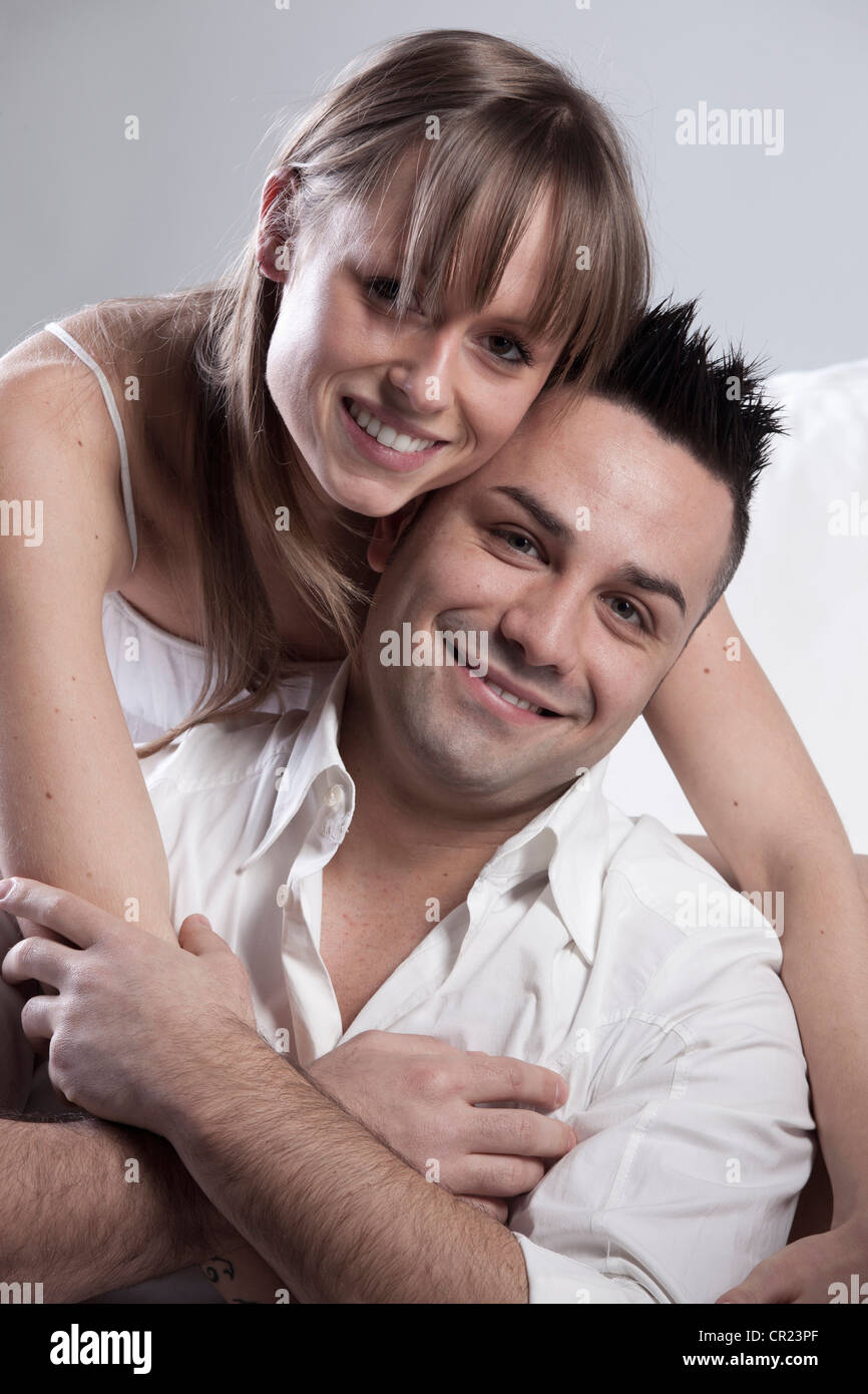 Smiling couple hugging on couch Stock Photo