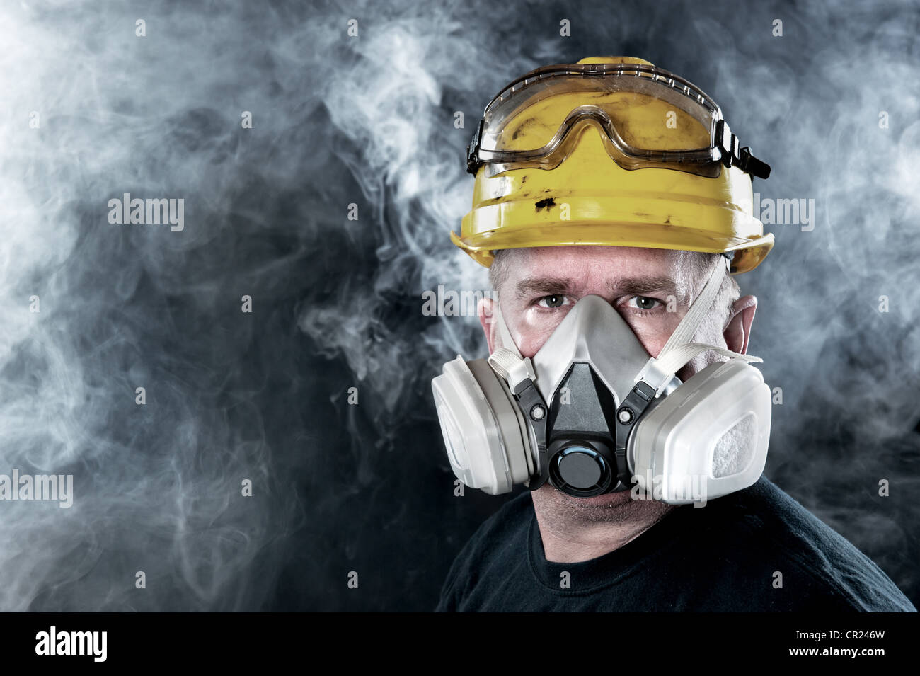 A rescue worker wears a respirator in a smoke, toxic atmosphere. Image show the importance of protection readiness and safety. Stock Photo