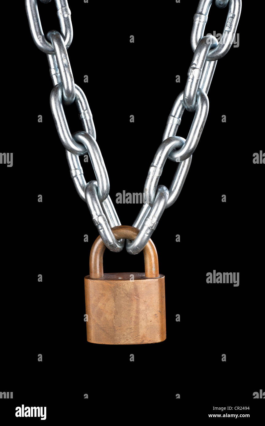 A vintage brass lock connecting a thick, chrome chain isolated on black. Stock Photo