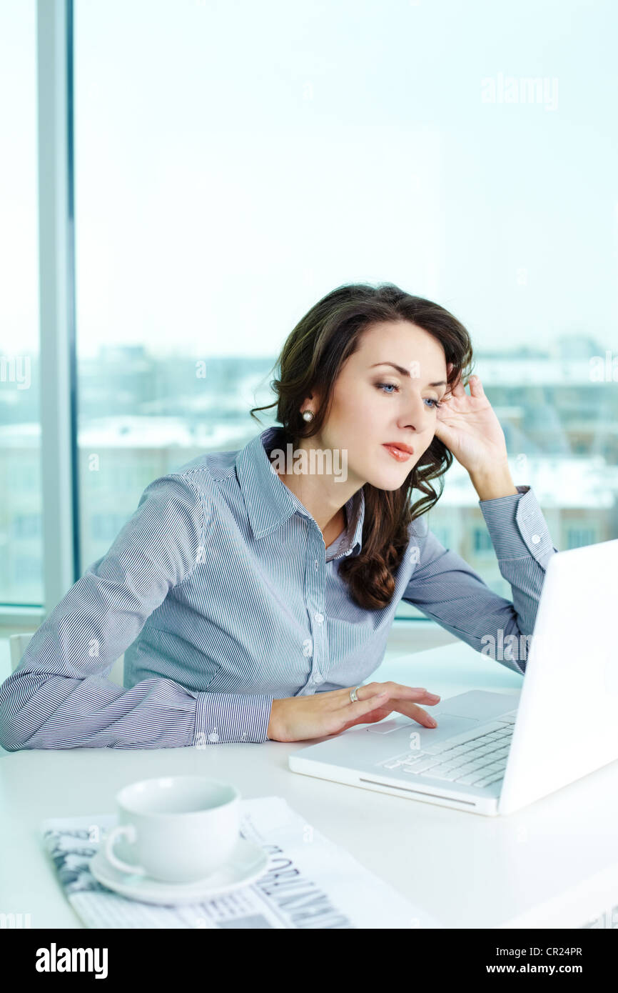 Business girl looking pensively at the laptop screen Stock Photo