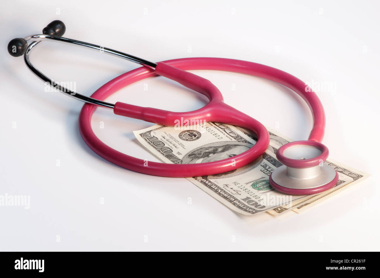medical stethoscope resting on dollar bills Stock Photo