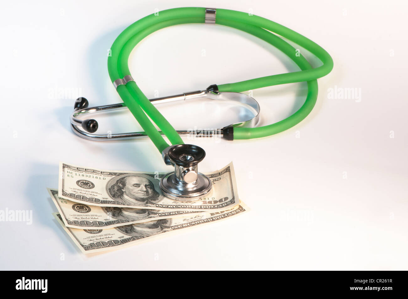 medical stethoscope resting on dollar bills Stock Photo