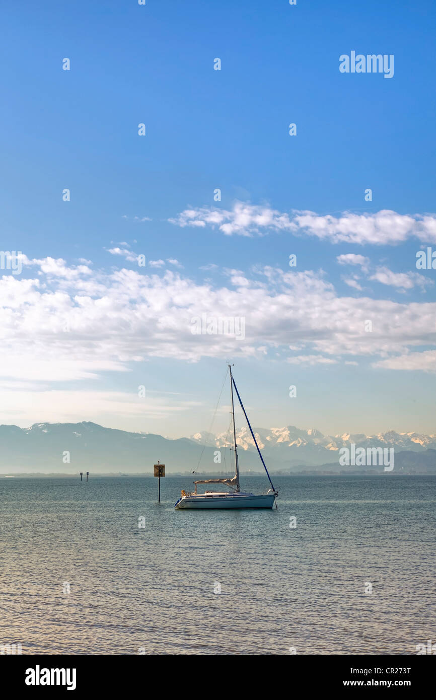 a lone sailing boat in the morning on a calm lake Stock Photo - Alamy