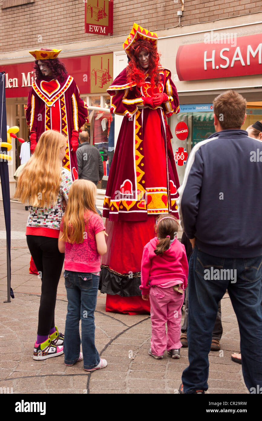 Stilt Walkers In King And Queen Of Hearts Costumes Street Stock