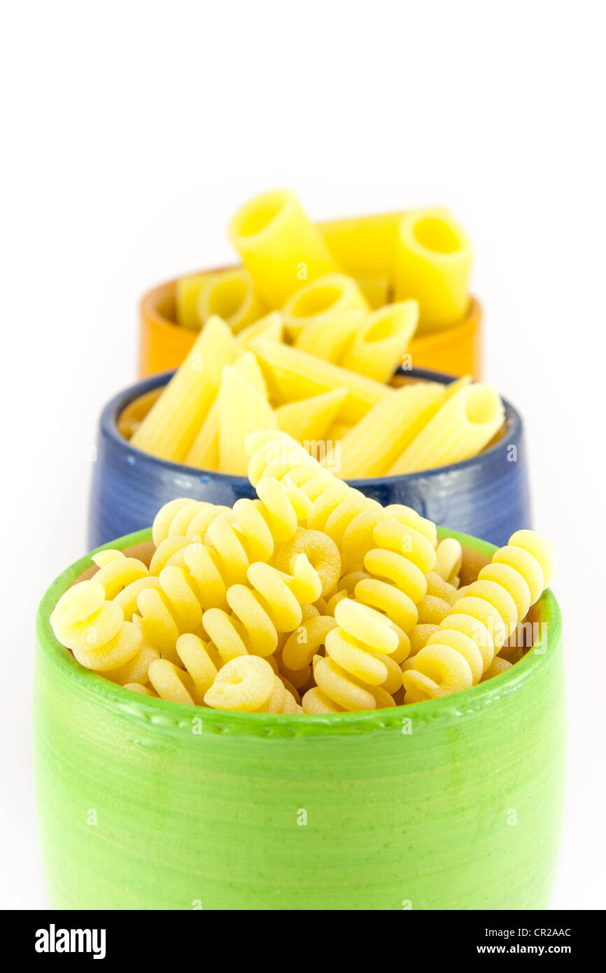 Fusilli, rigatoni and pens pasta in a green, blue and orange jar