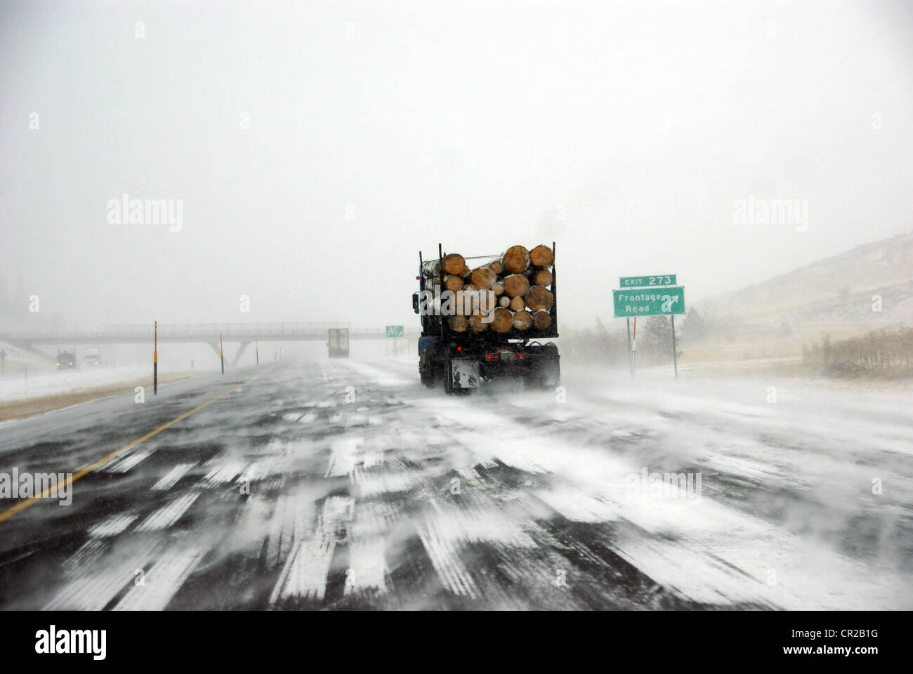 Logging truck on icy road  during winter storm in Eastern Oregon Stock Photo