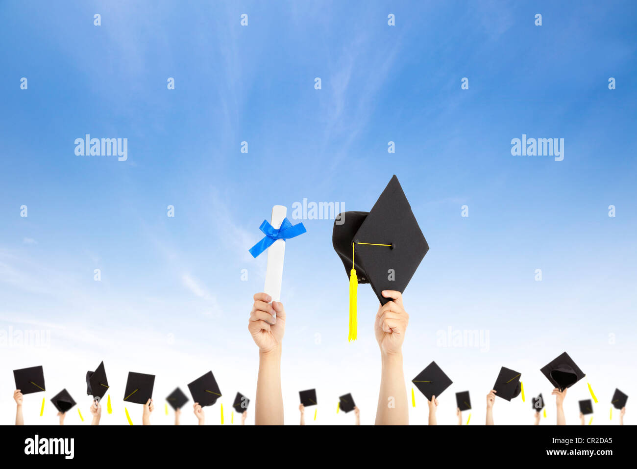 hand holding graduation hats and diploma certificate with cloud background Stock Photo