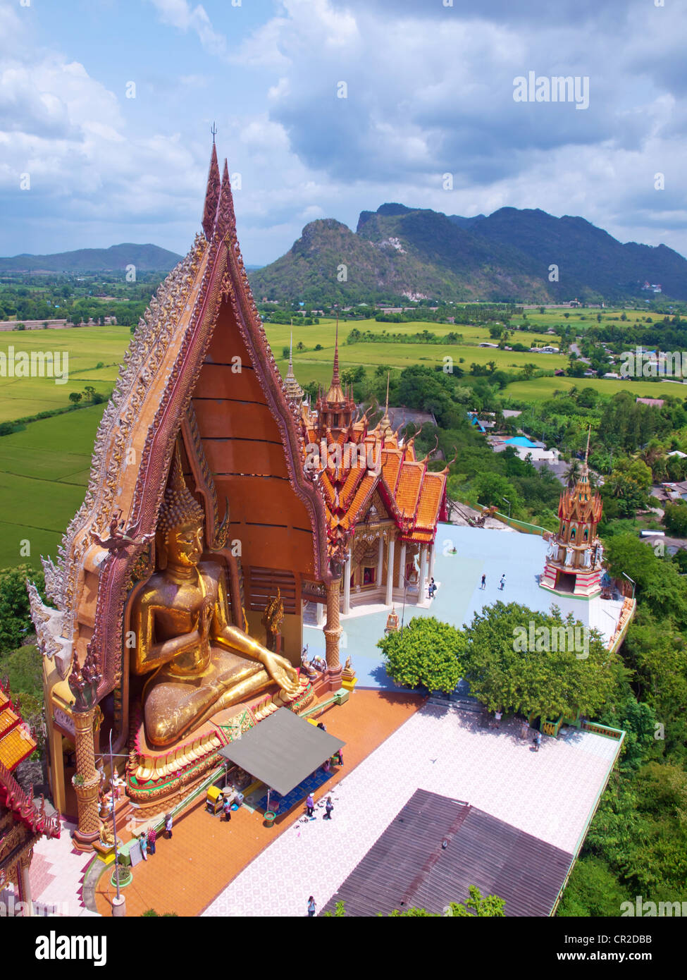 Golden buddha statue with rice fields and mountain in Wat Tham Sua(Tiger Cave Temple), Tha Moung, Kanchanburi, Thailand Stock Photo