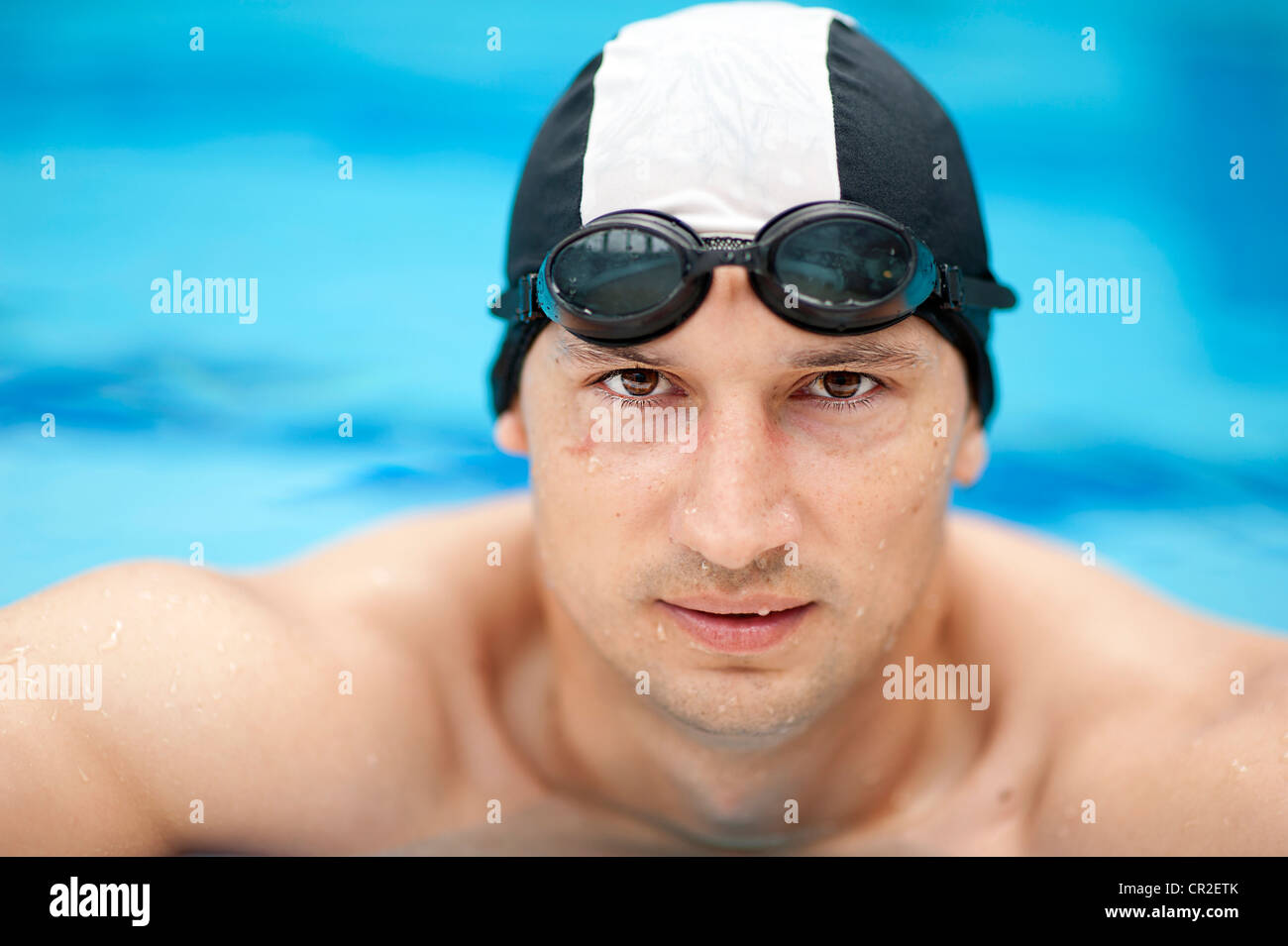 Professional male swimmer wearing a hat and goggles Stock Photo