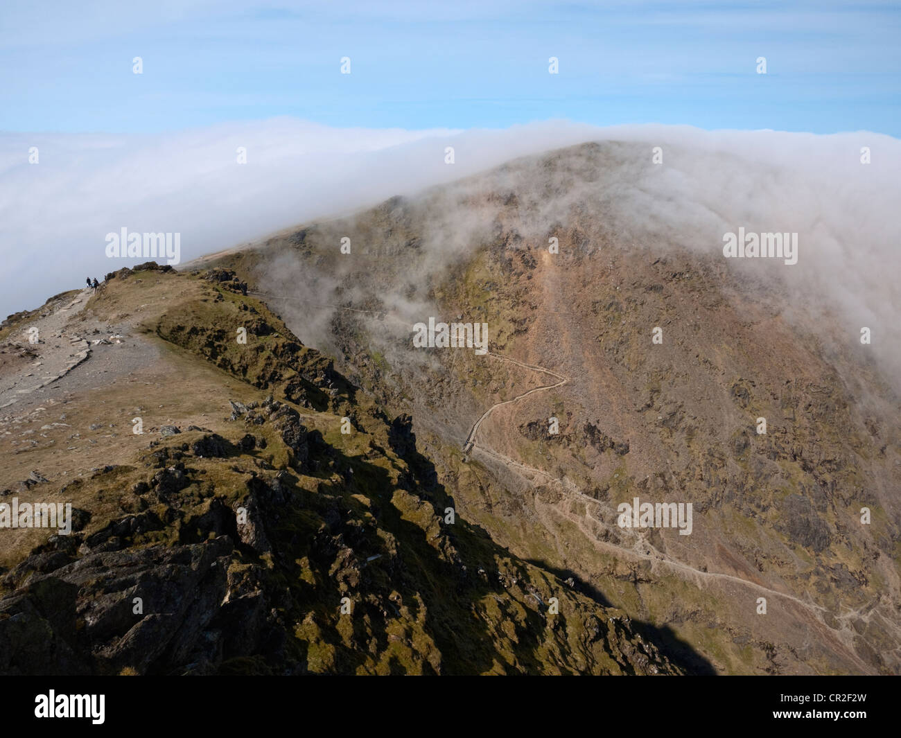 Viewed from Snowdon, a cloud inversion pours over Garnedd Ugain/Crib y Ddysgl and the 'zig zags' section of the Pyg Track Stock Photo