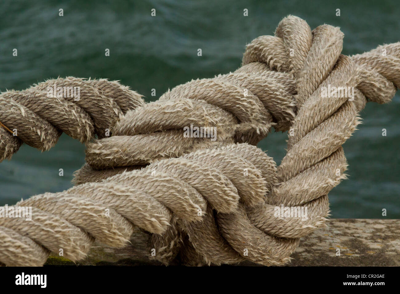 Mooring rope fastened to eye on harbour wall Stock Photo