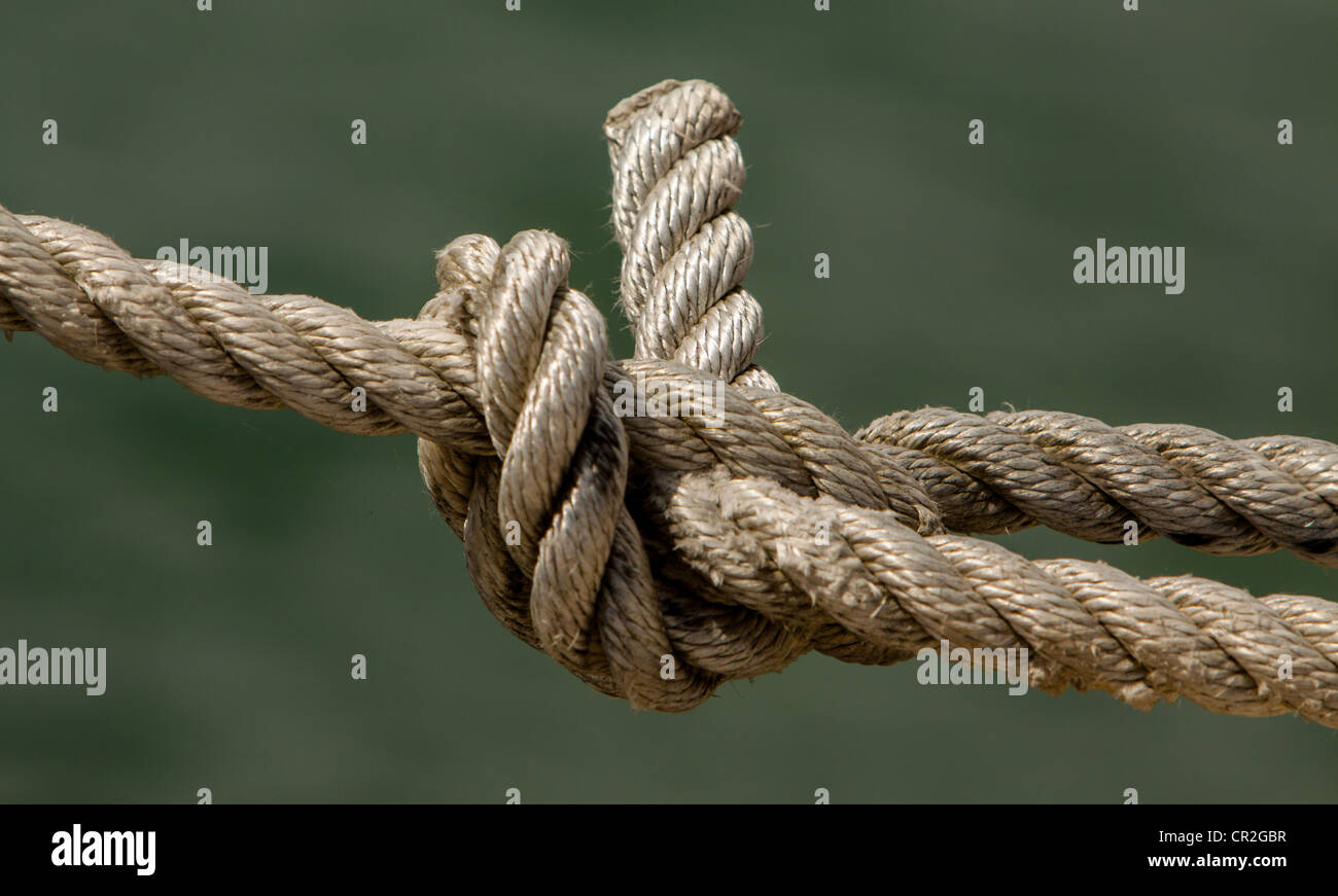 Mooring rope fastened to eye on harbour wall Stock Photo