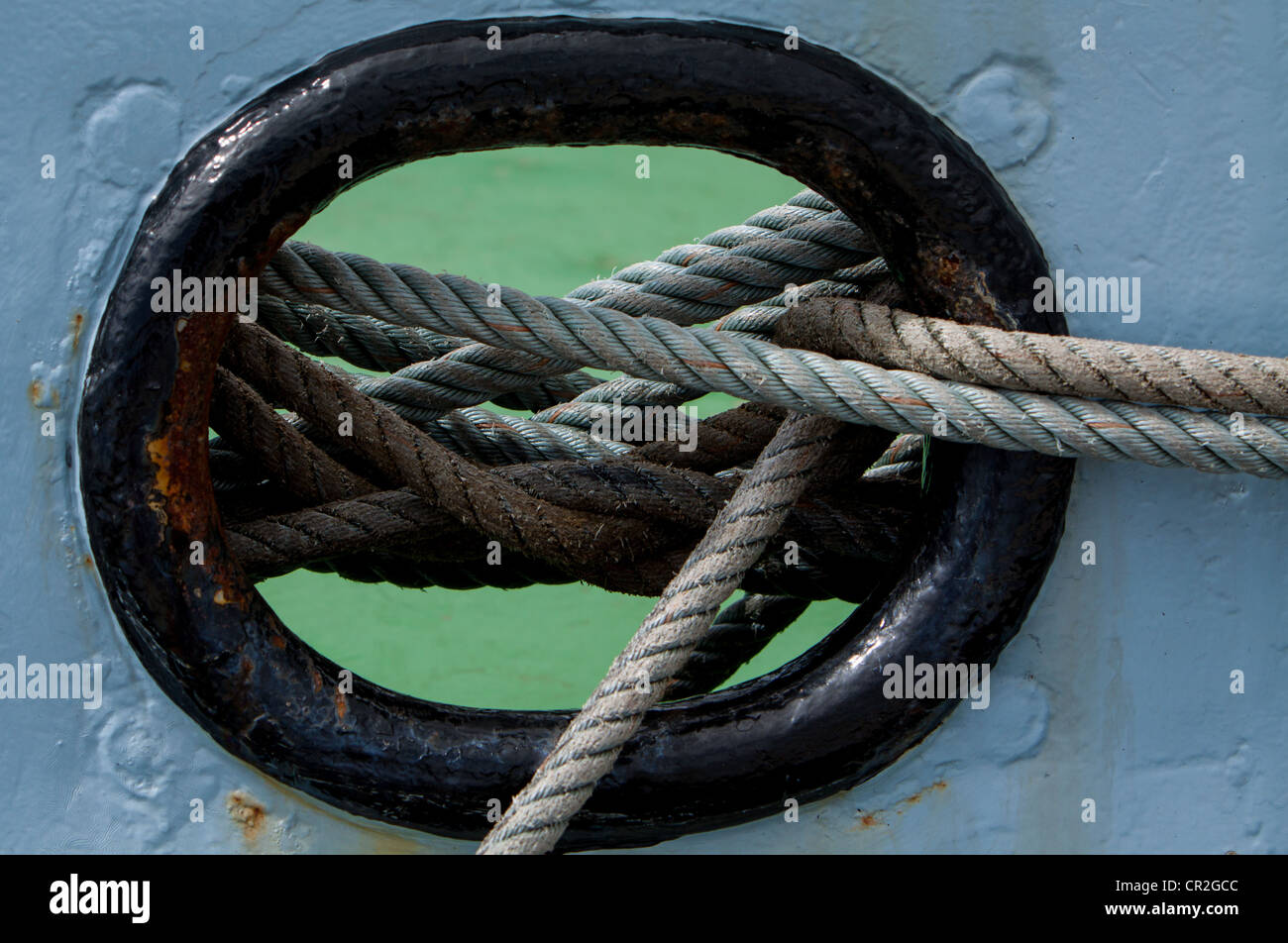 Mooring lines coming out of a hole in a ship Stock Photo