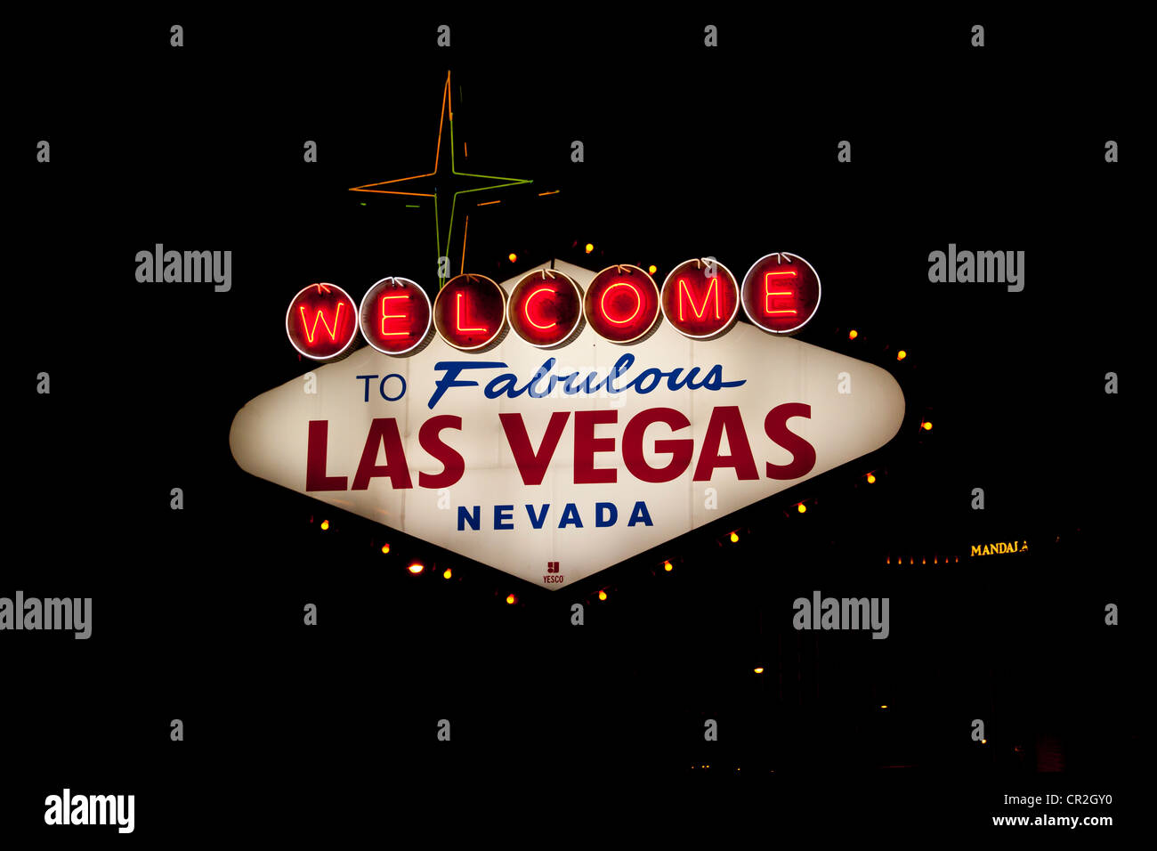 The famous welcome to fabulous Las Vegas neon sign as you enter Las Vegas at night with Mandalay Bay Hotel  and casino behind. Stock Photo